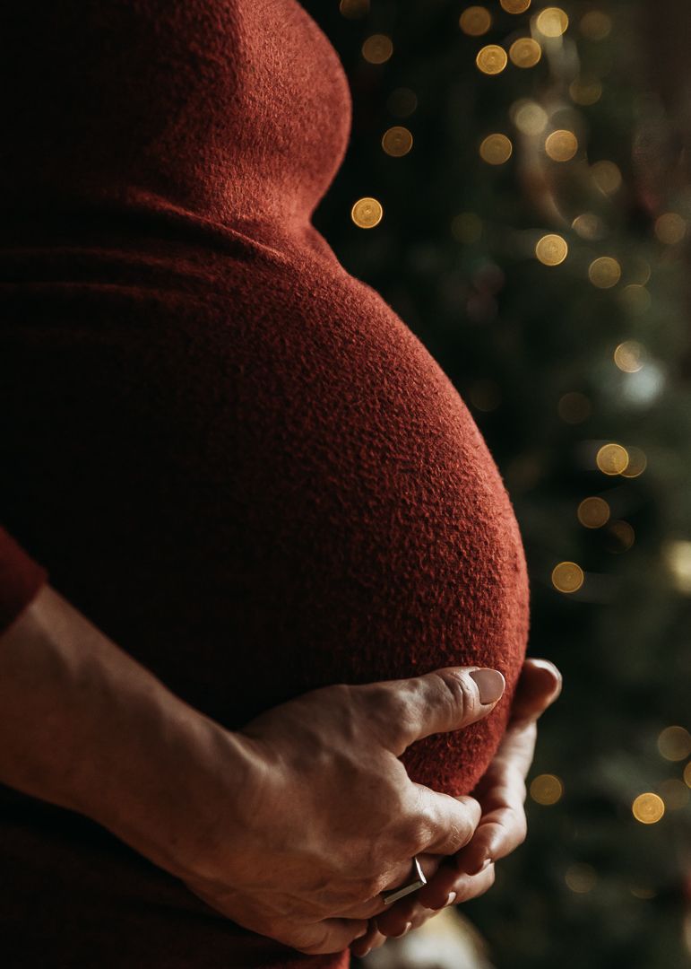 A series of photos showing hands cradling a pregnant belly with warm bokeh lights in the background.