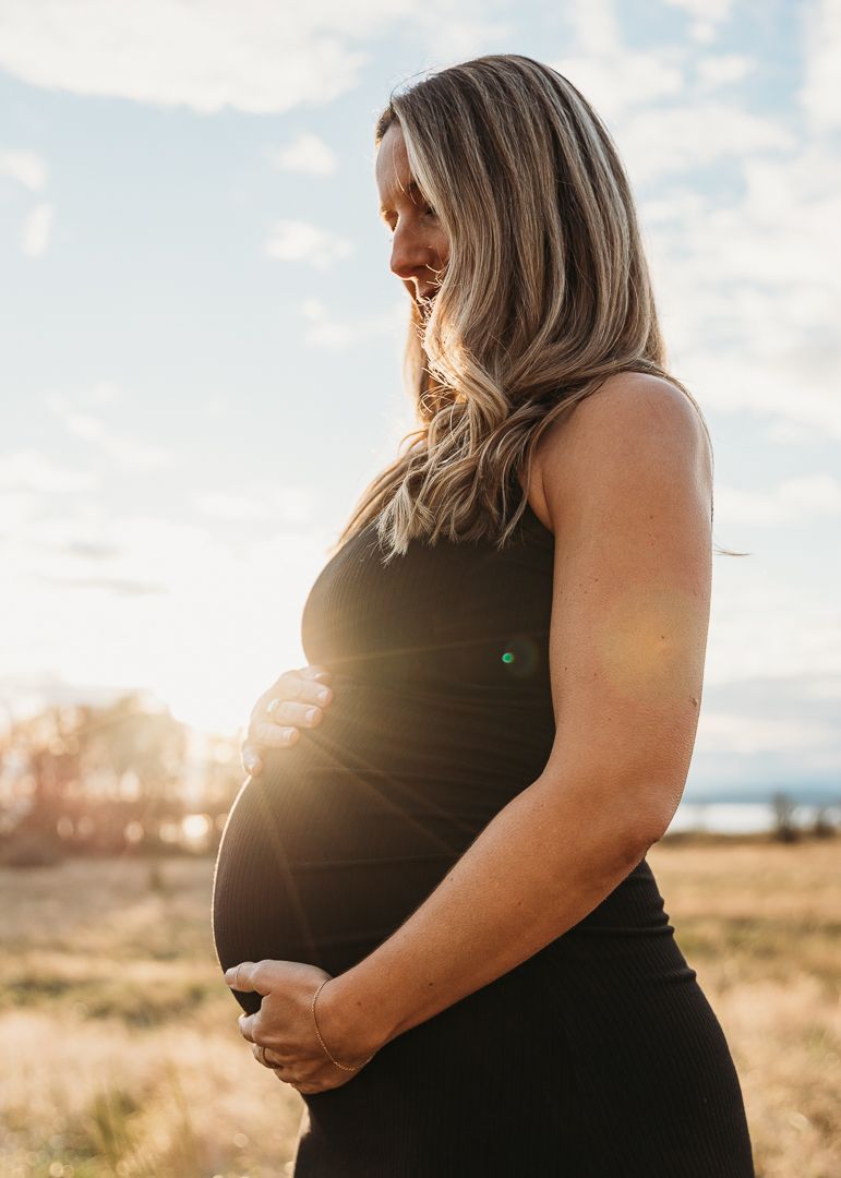 A series of silhouetted maternity photos at sunset shows a pregnant woman in black against a bright sky.