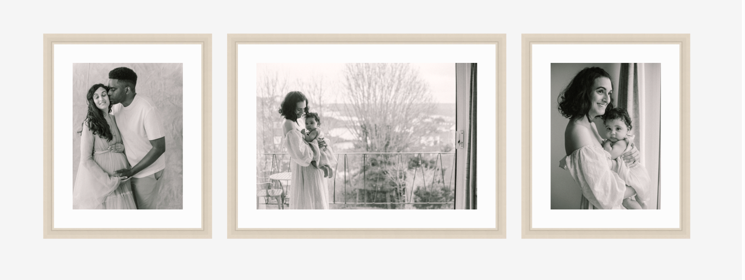 A collection of framed black and white photographs arranged on a wall in a gallery-style display.