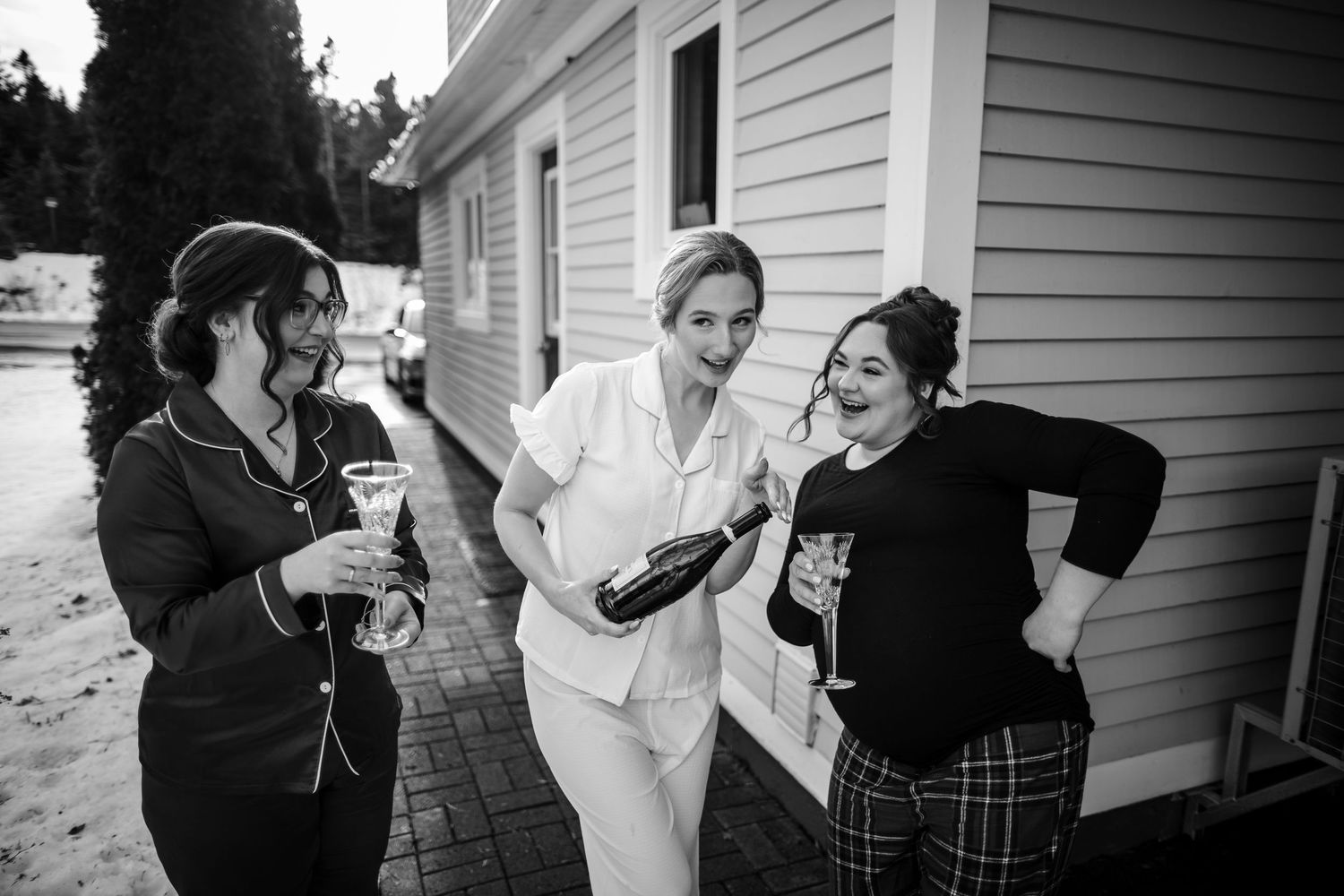 A series of black and white photos showing people interacting and embracing in emotional moments outside a house.
