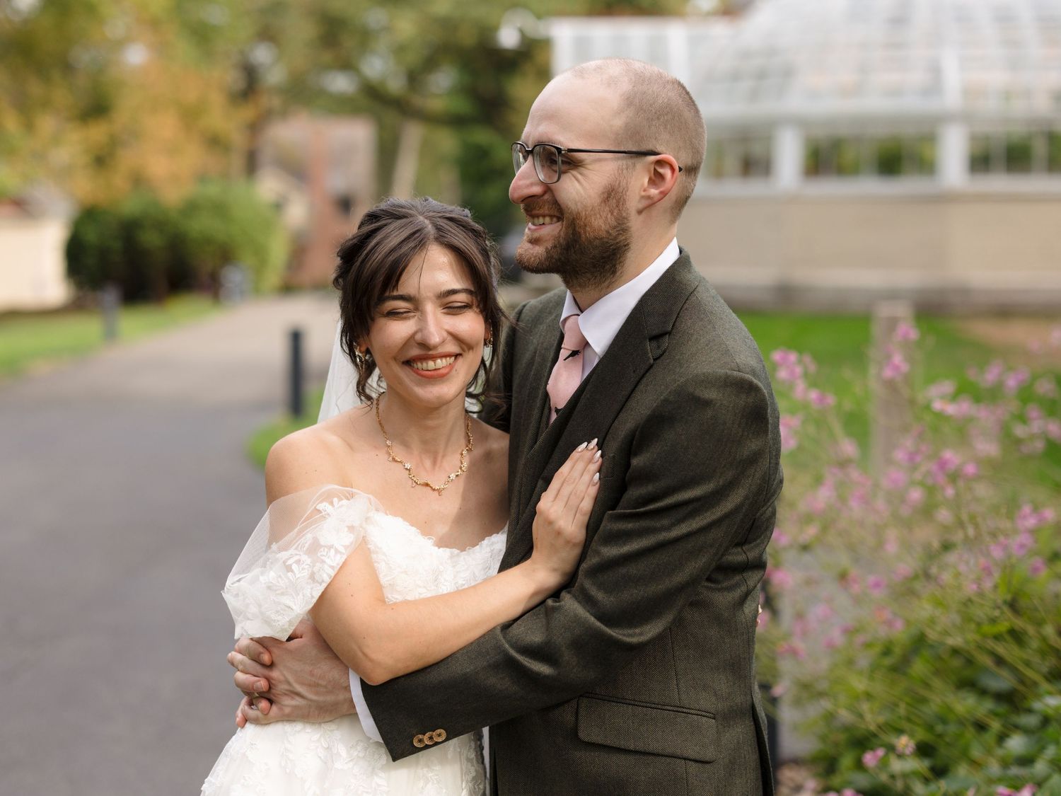 A couple shares intimate moments in a garden setting during their wedding photoshoot.