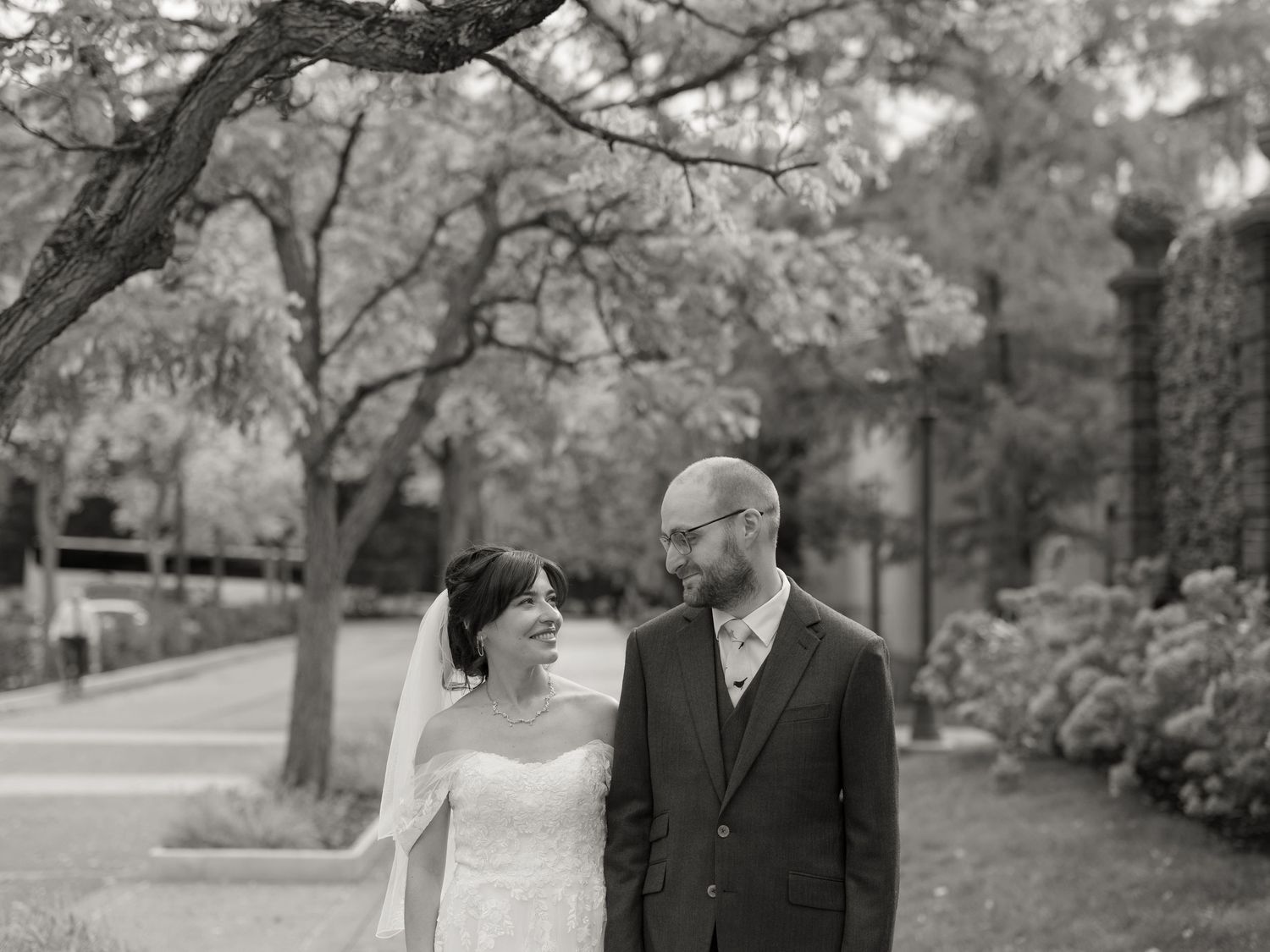 A couple shares a romantic moment in a park setting during their wedding photo session.