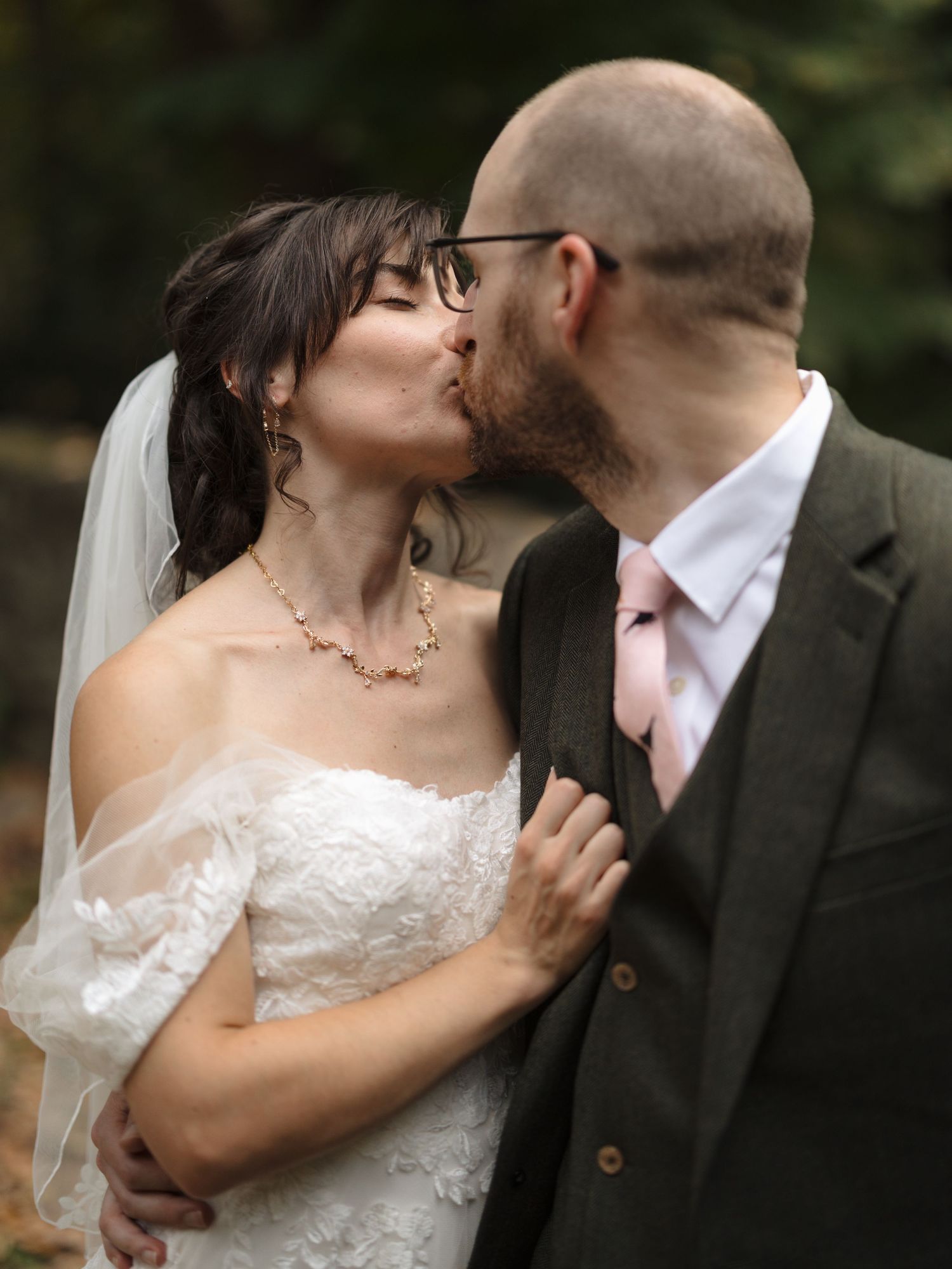 Newlyweds share intimate kisses in a series of candid outdoor wedding photos.