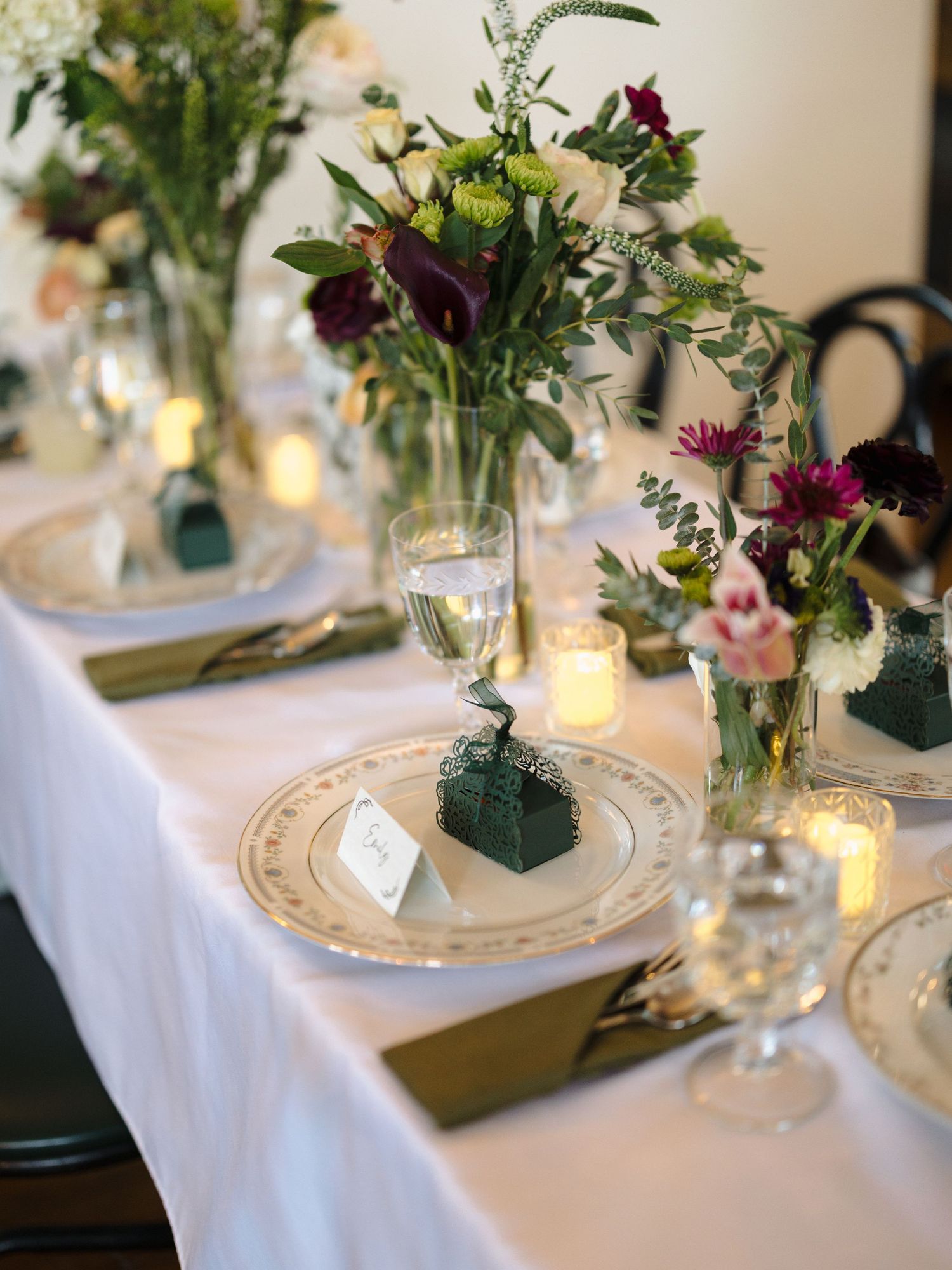 Elegant wedding reception table settings with fresh floral centerpieces and vintage place settings on white linens.
