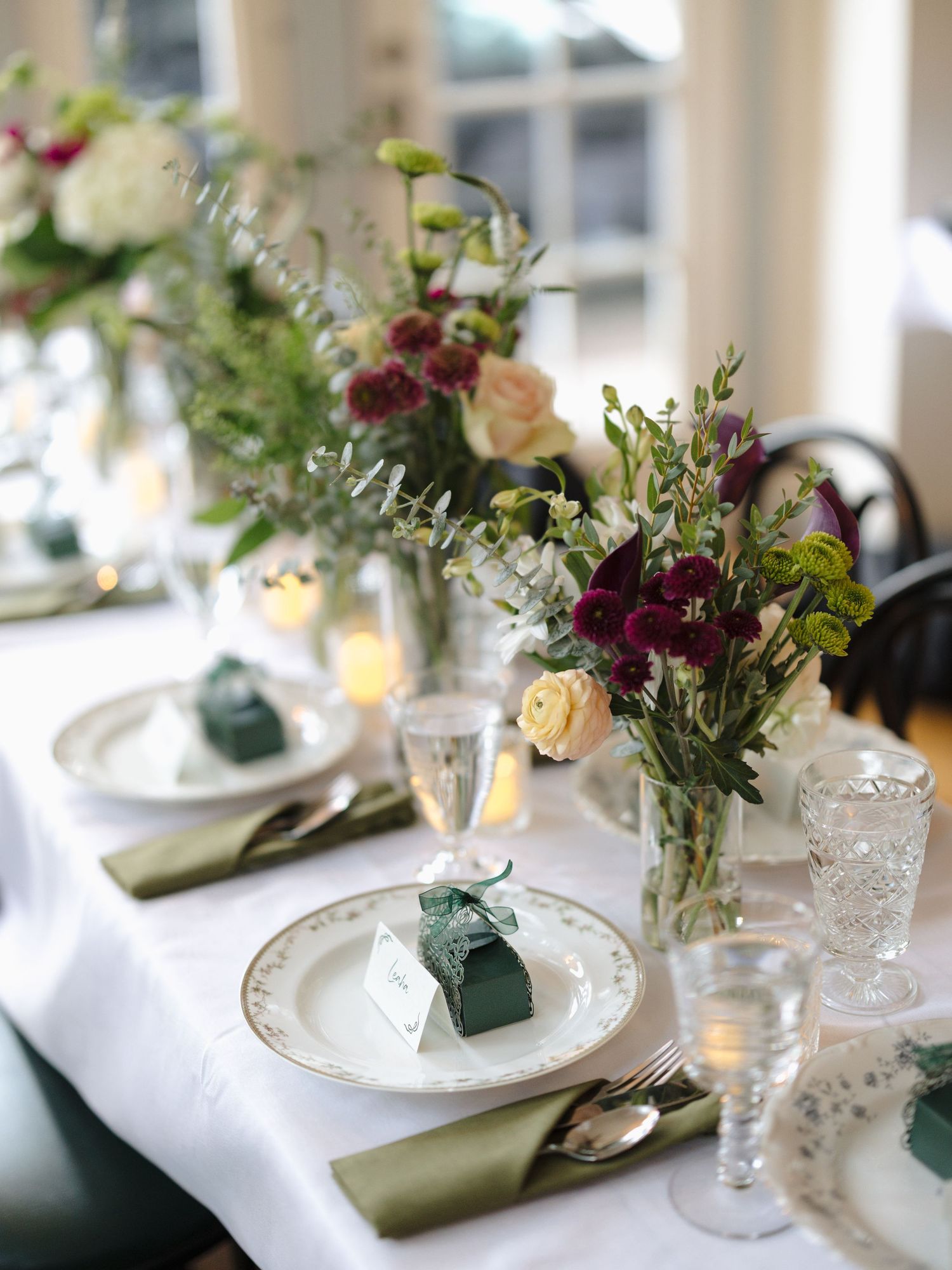 Elegant table settings with delicate floral arrangements and crystal glassware at a formal event.