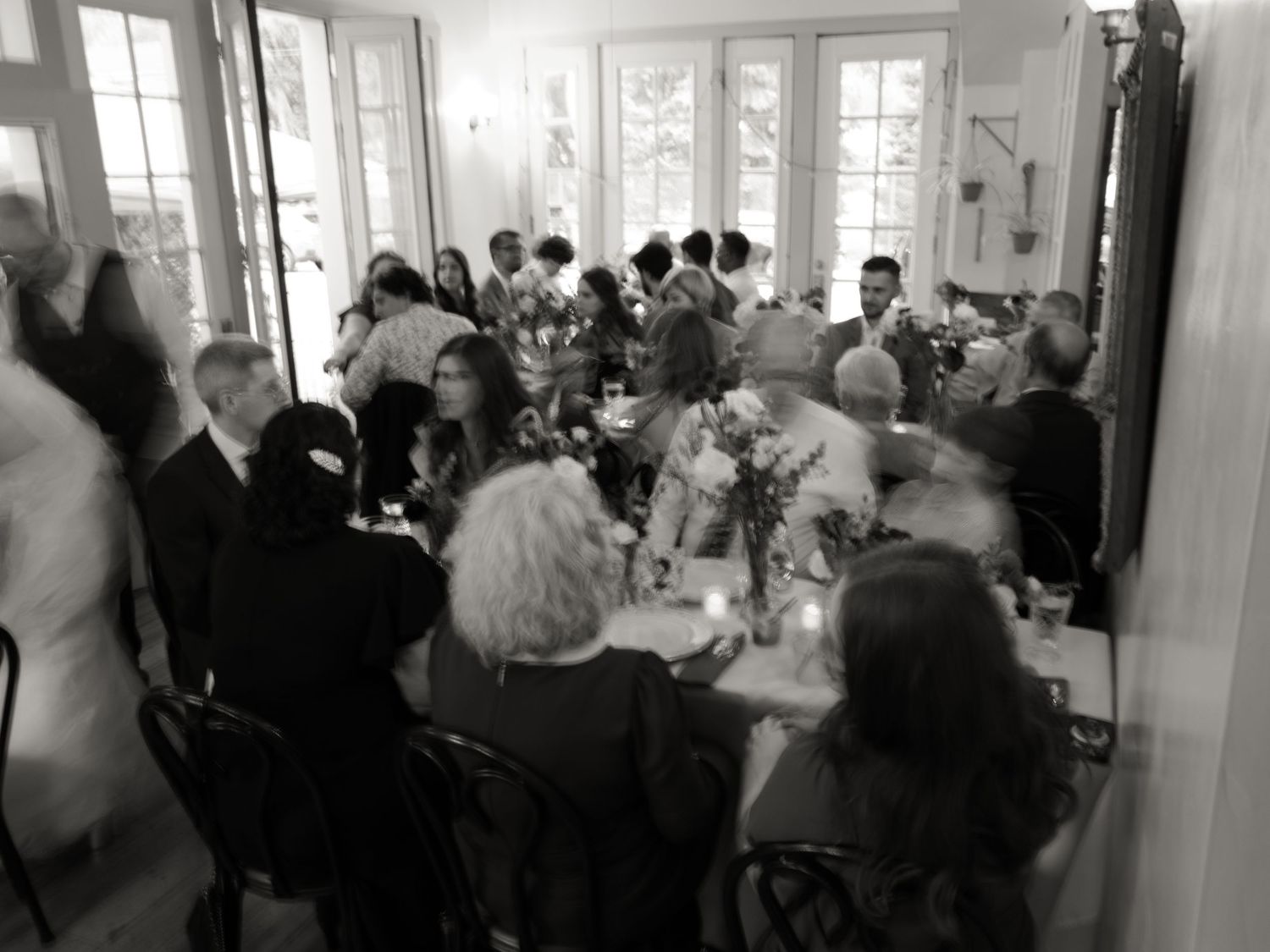 Black and white photograph showing a crowded reception hall filled with guests mingling at a formal event.