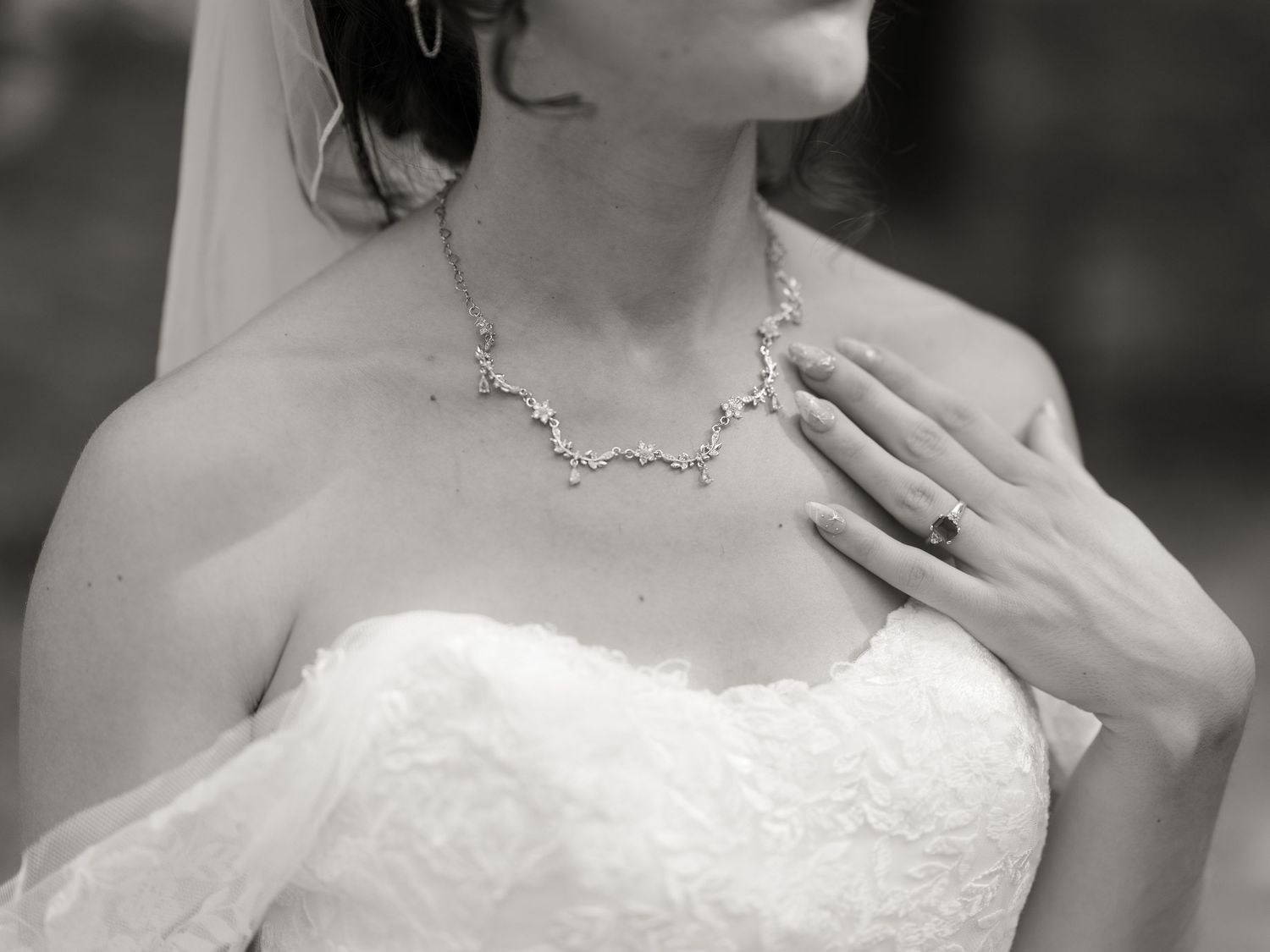 A black and white collage of wedding photos showing close-up details of a bride in a strapless wedding gown.