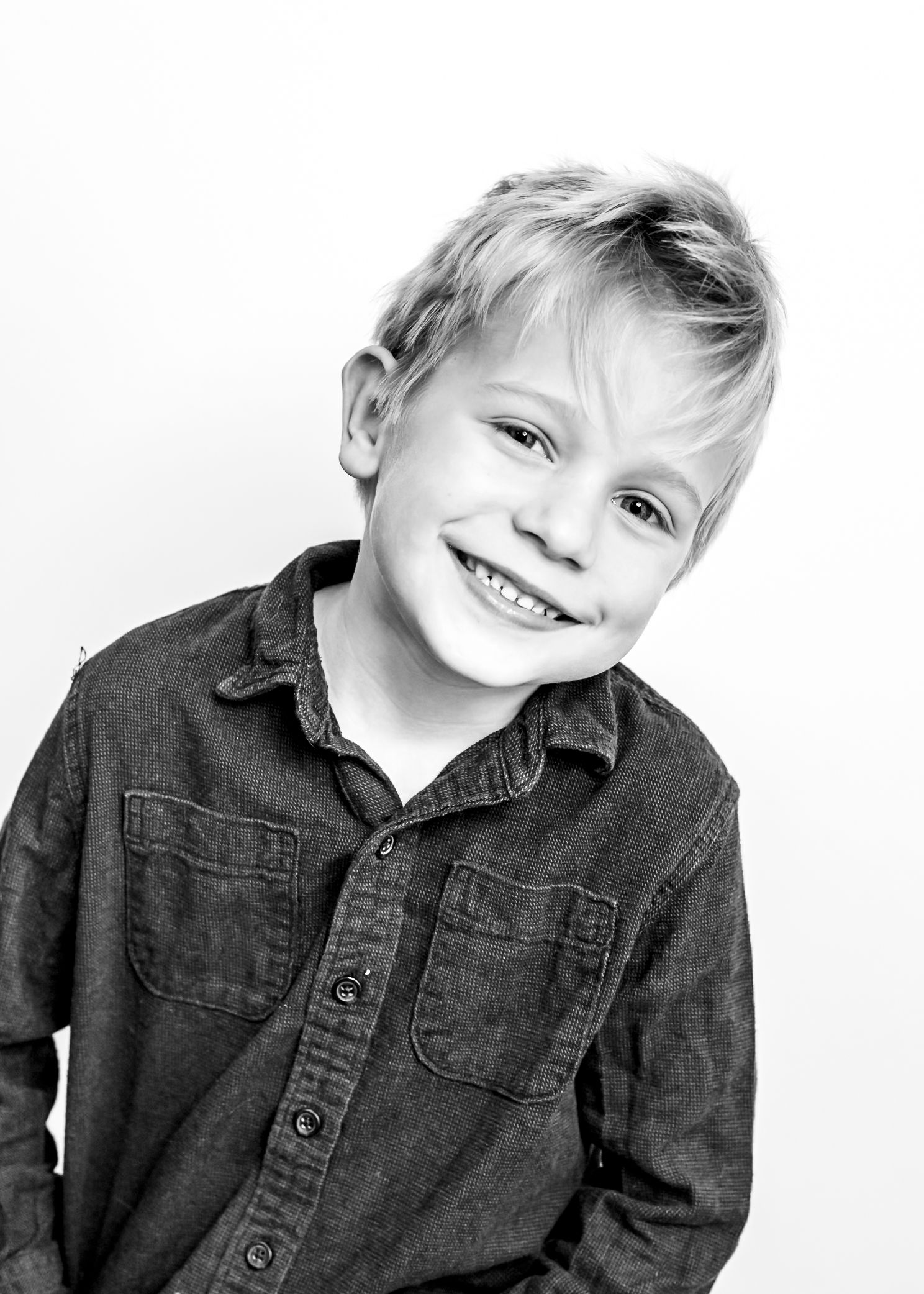 Young child wearing a dark denim button-up shirt poses playfully against white background in multiple shots.
