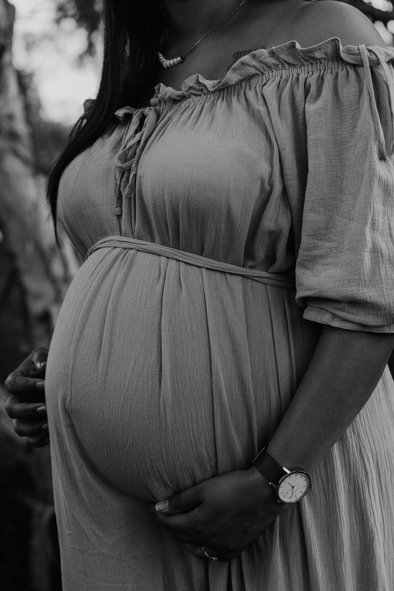 A black and white close up of a pregnant mum's belly