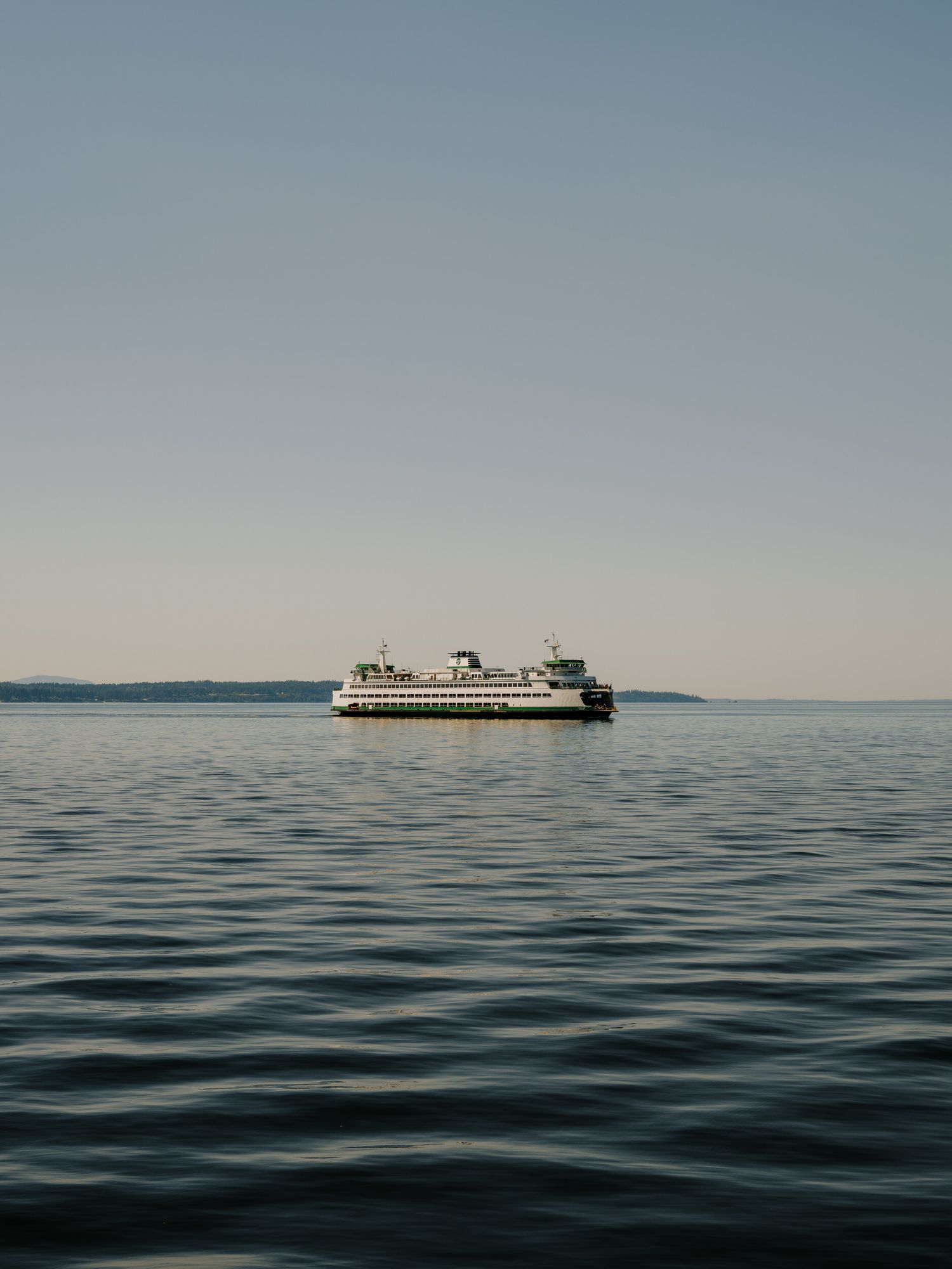 A Washington State ferry crosses calm waters on Puget Sound during a serene evening voyage.