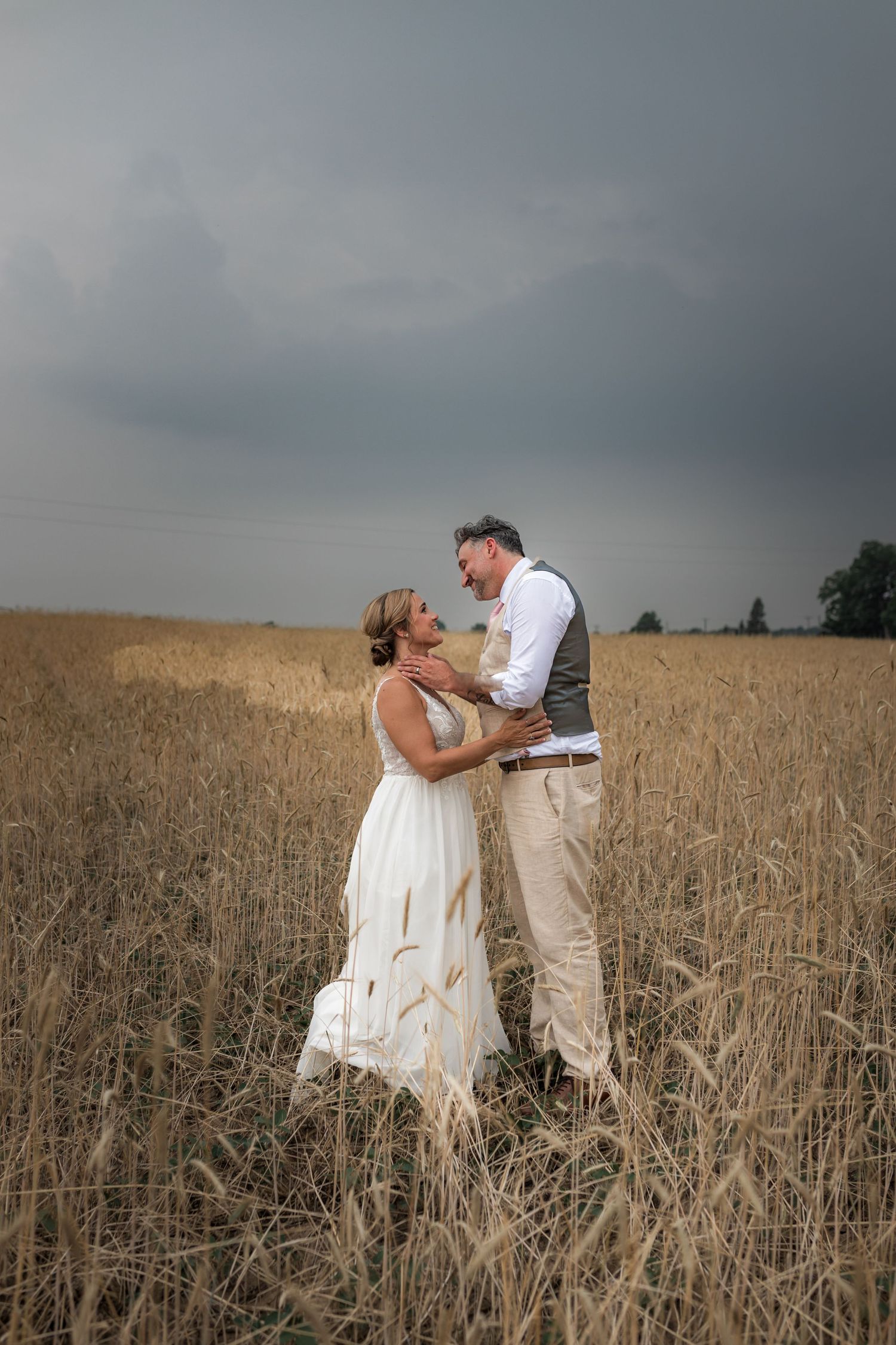 Wedding couple sharing intimate moments in a serene wheat field.
