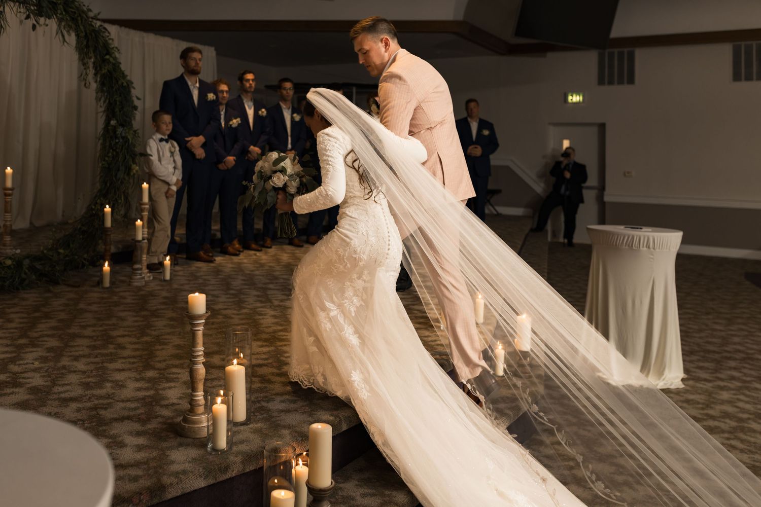 Wedding couple sharing first dance in elegantly decorated reception hall.