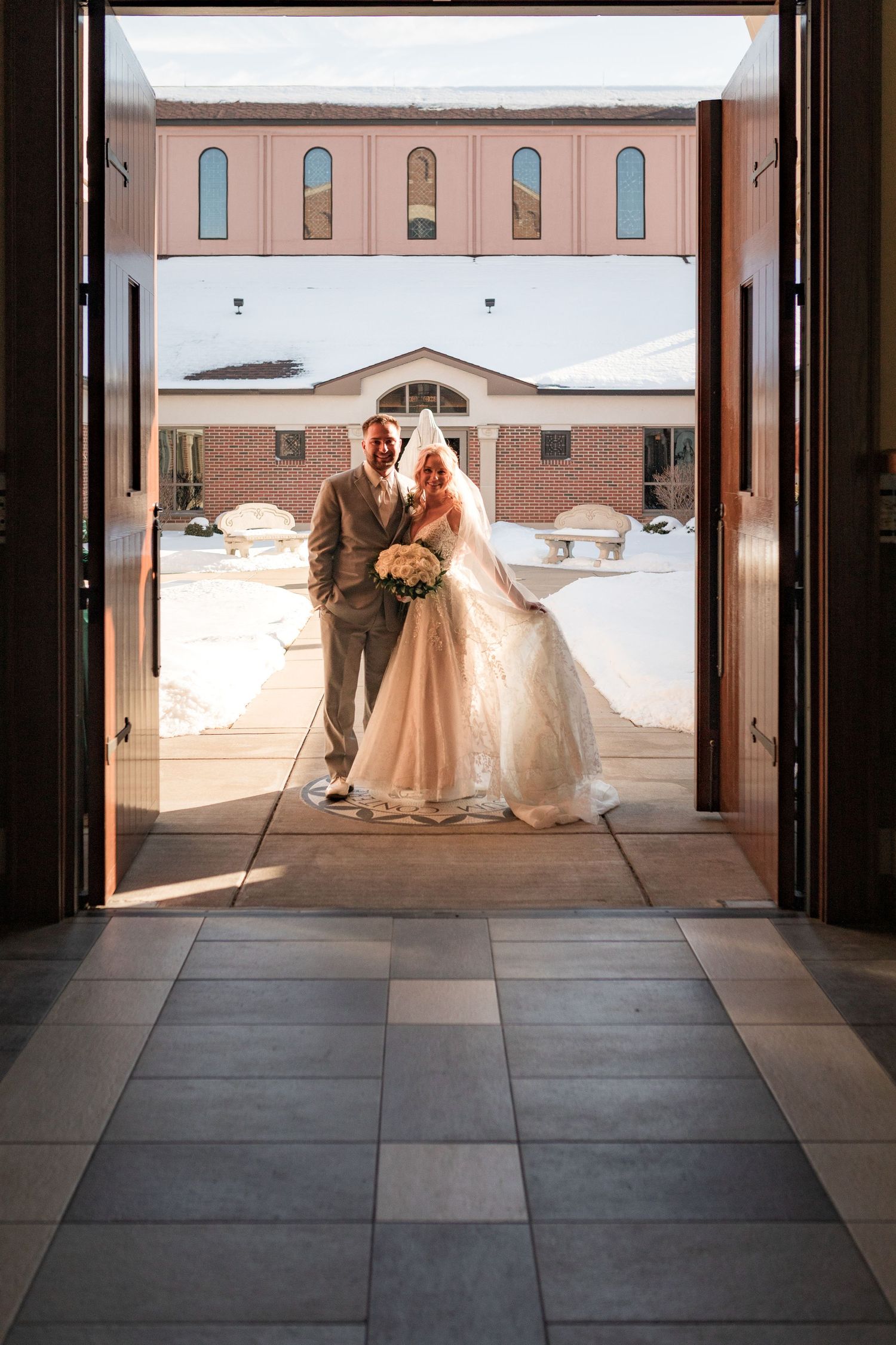 Silhouettes against bright doorway entrance of a church or venue during a wedding ceremony.