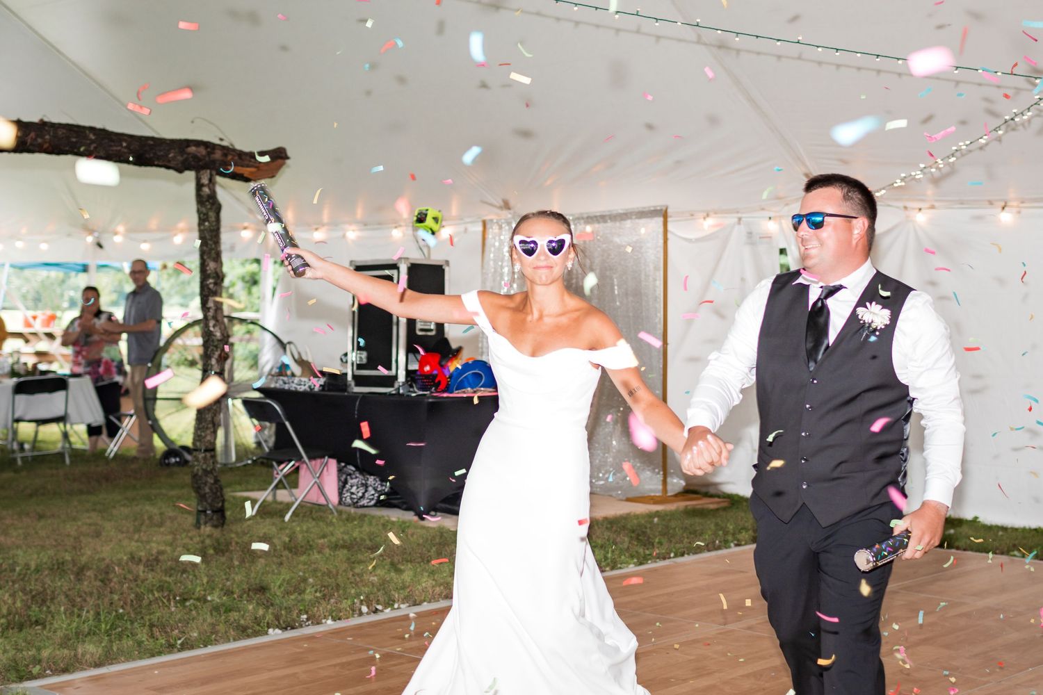 Wedding guests celebrate with sparklers during an outdoor evening reception.