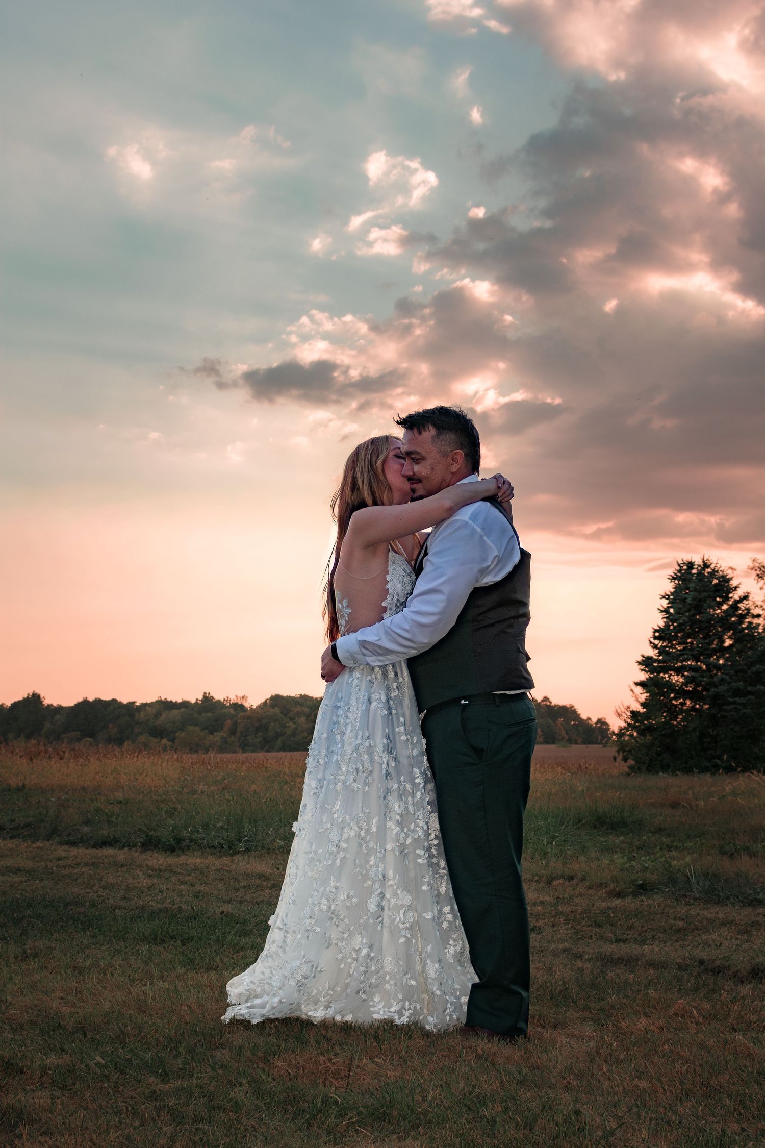 Sunset wedding portraits showing tender moments between newlyweds in a golden field.