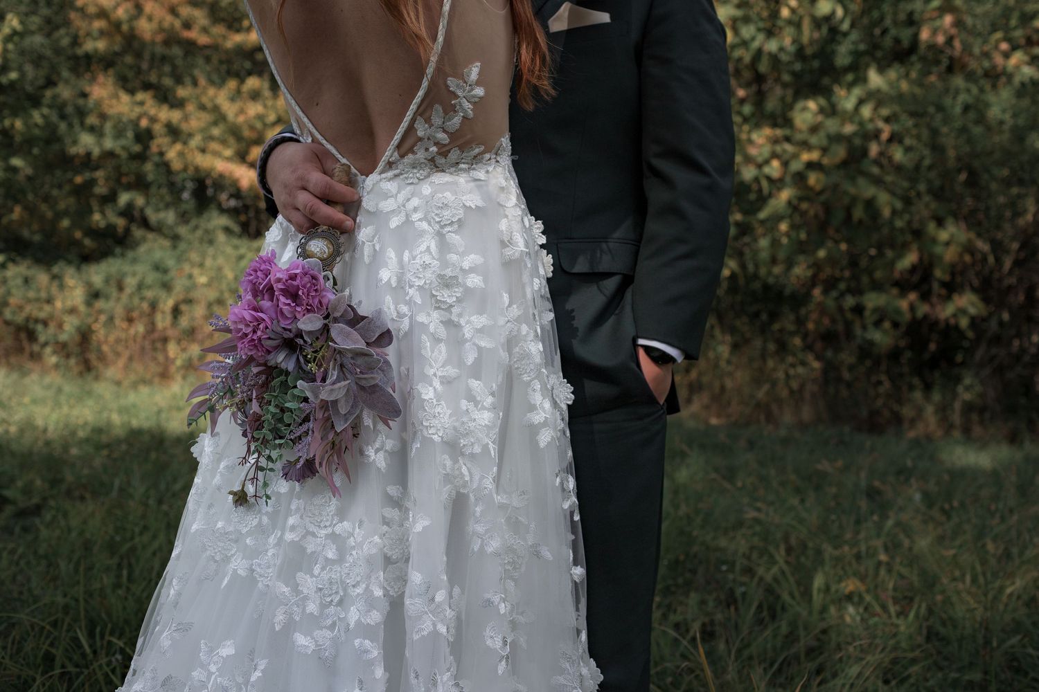 Wedding couple portraits featuring a detailed white lace gown against a natural outdoor backdrop.