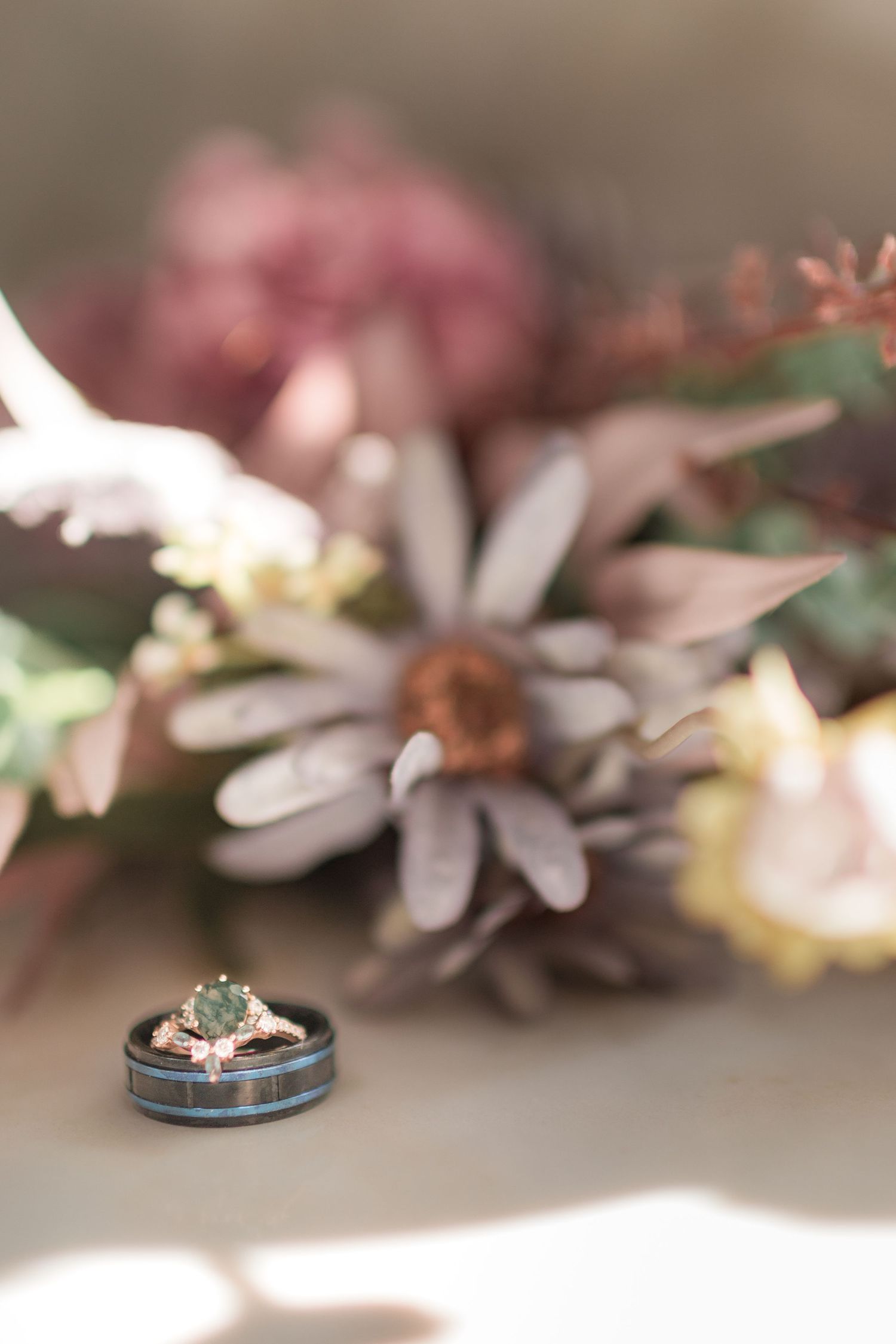 Wedding rings displayed artistically among soft pink and white floral elements.