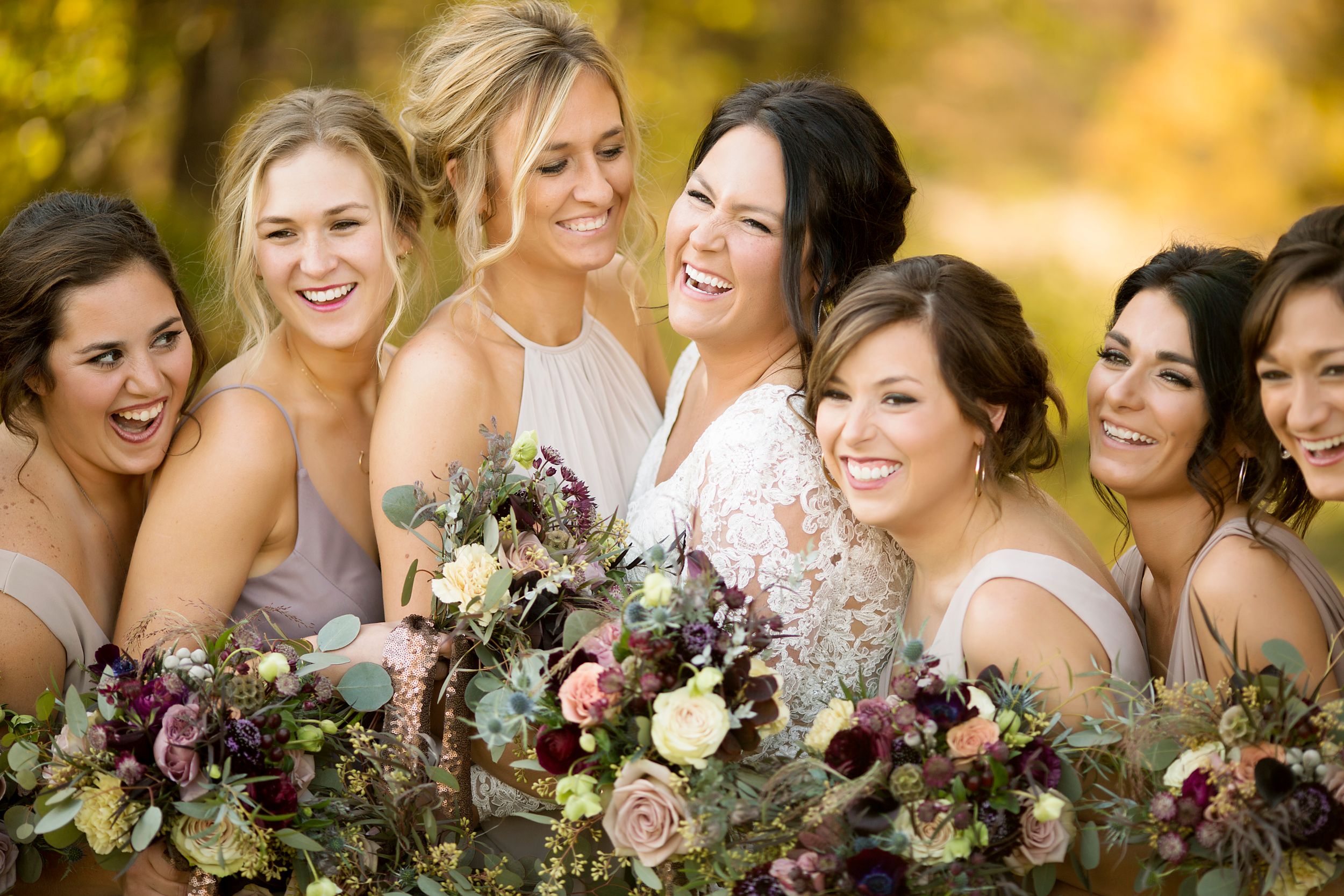 Group celebrating with beautiful fall-colored bouquets outdoors.