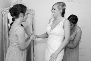 Getting ready scene shows wedding dress preparations with elegant vintage mirror.
