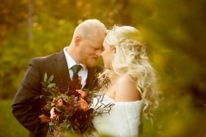 Romantic sunset portrait with autumn-colored wedding bouquet.