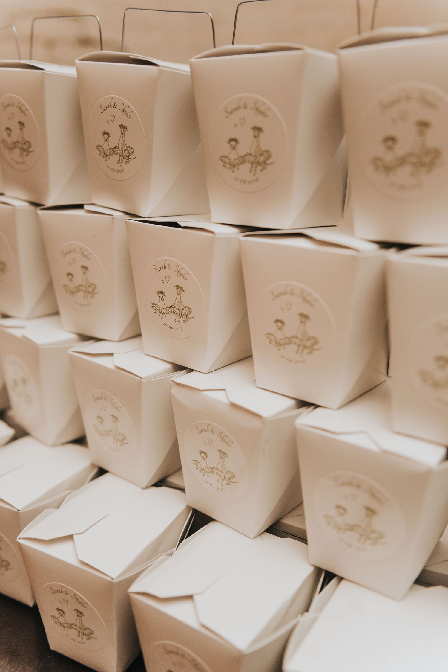 Rows of white takeout containers arranged in a stack with logo stamps displaying a small decorative design.