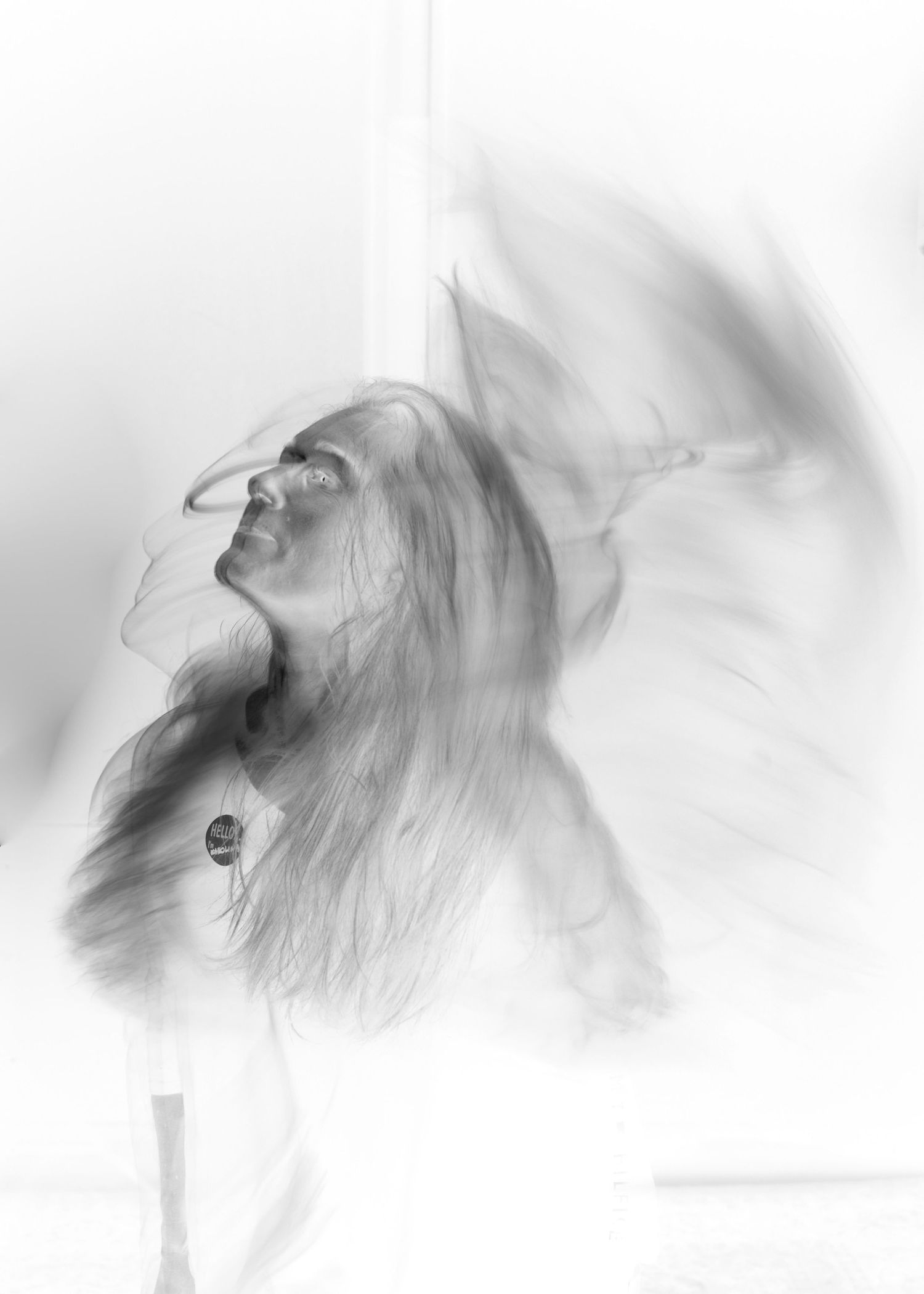Artistic black and white portrait showing ethereal double exposure effect with dreamy motion blur.