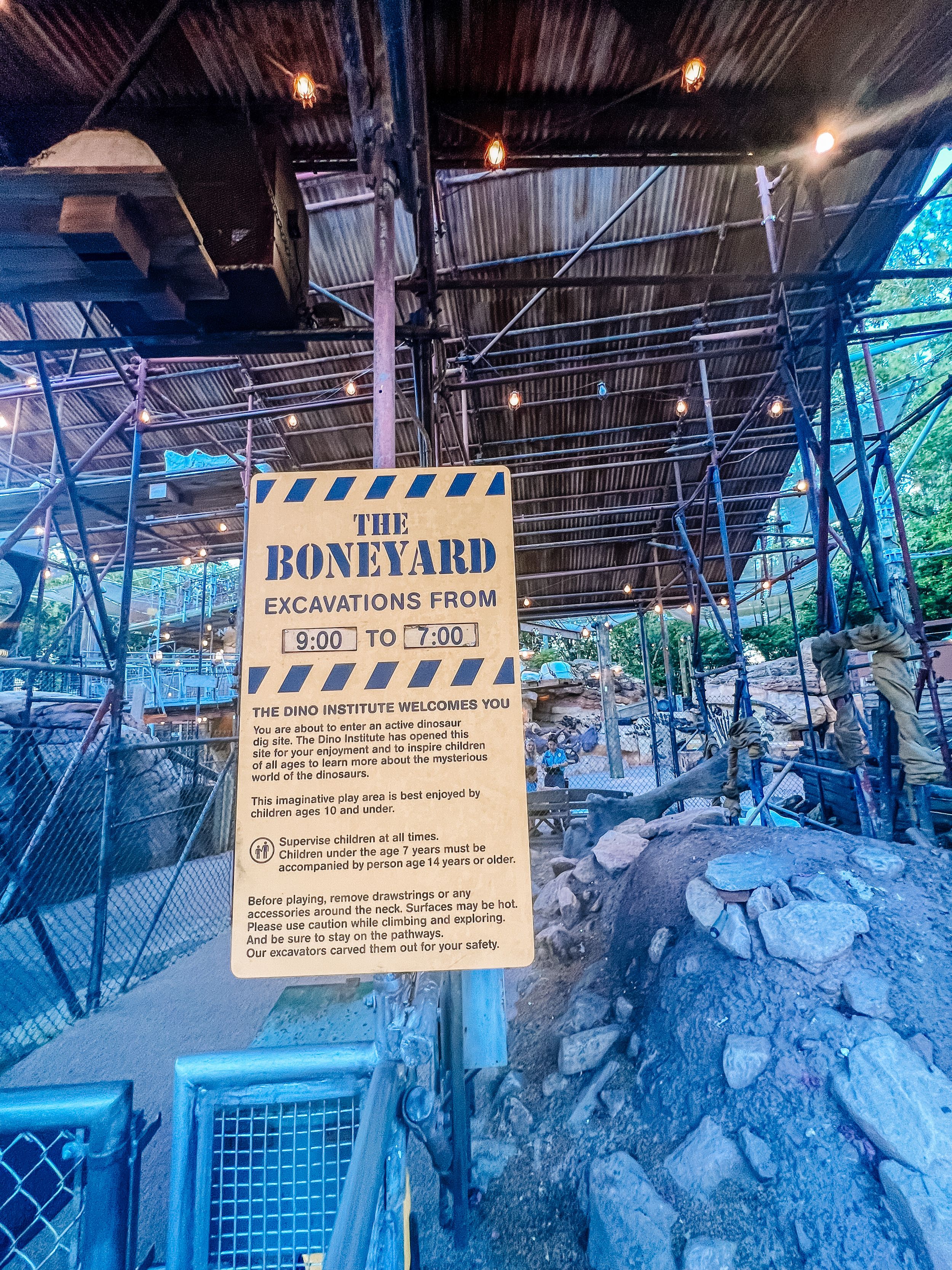 Night view of a dimly lit excavation site with snow-covered ground and glowing blue lighting creating an eerie atmosphere.
