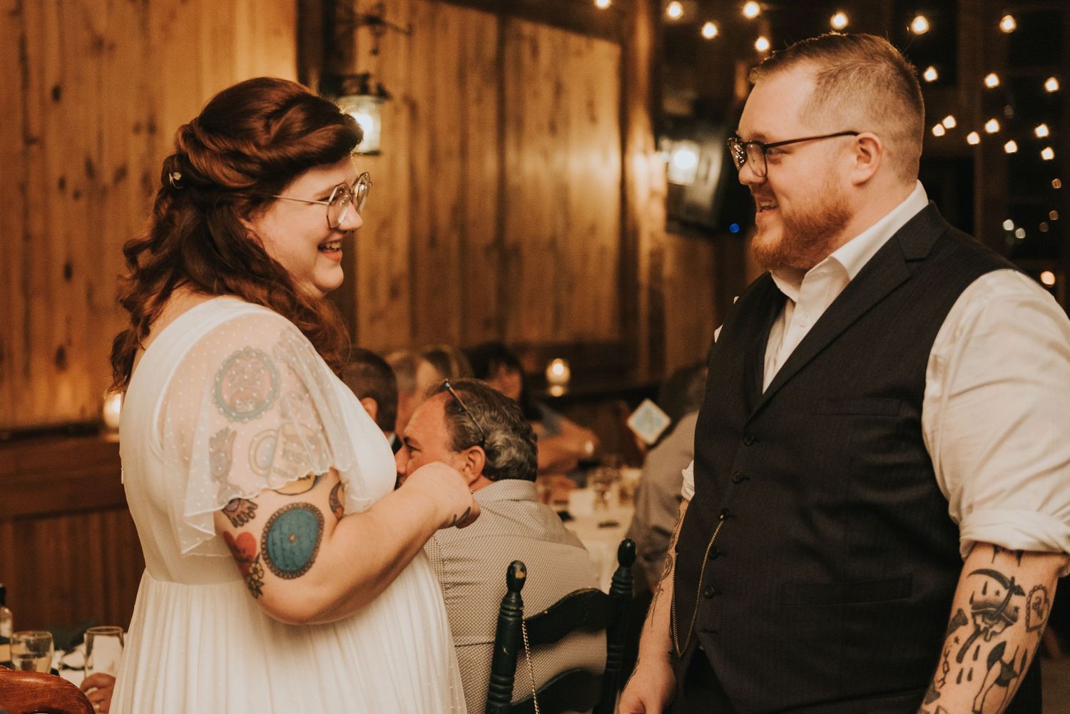 A rustic wooden barn wedding venue illuminated with warm string lights creates a cozy and intimate atmosphere.