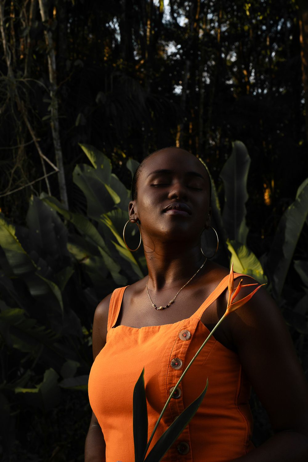 Portrait d'une femme en haut orange dans la forêt guyanaise