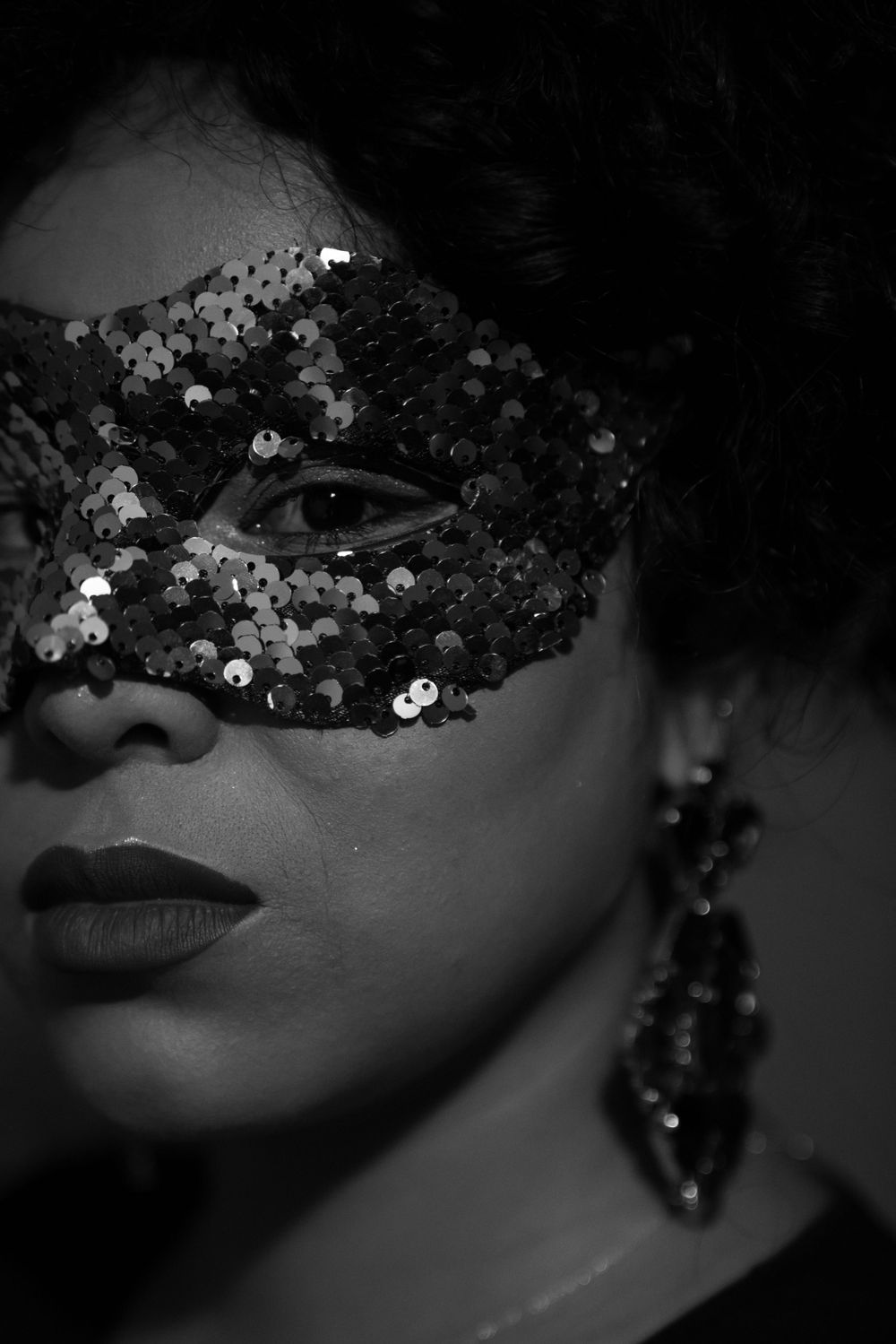 Portrait en noir et blanc d'une femme portant un masque pailleté