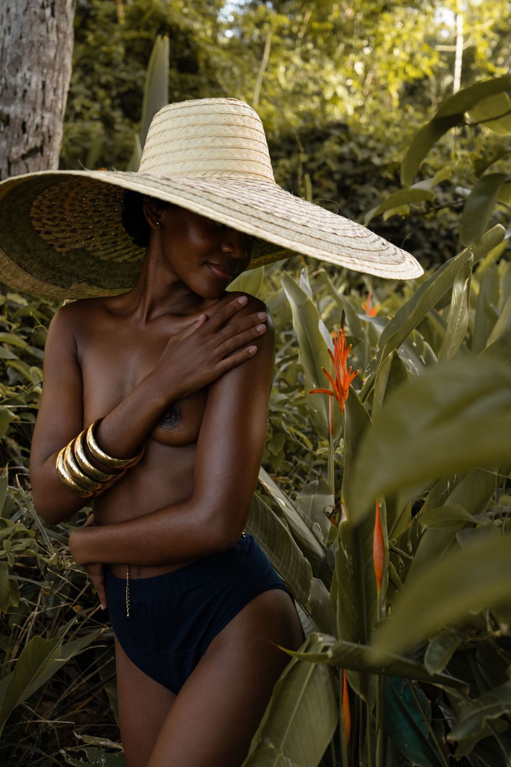 Portrait fine art d'une femme au grand chapeau de paille dans la végétation de Guyane