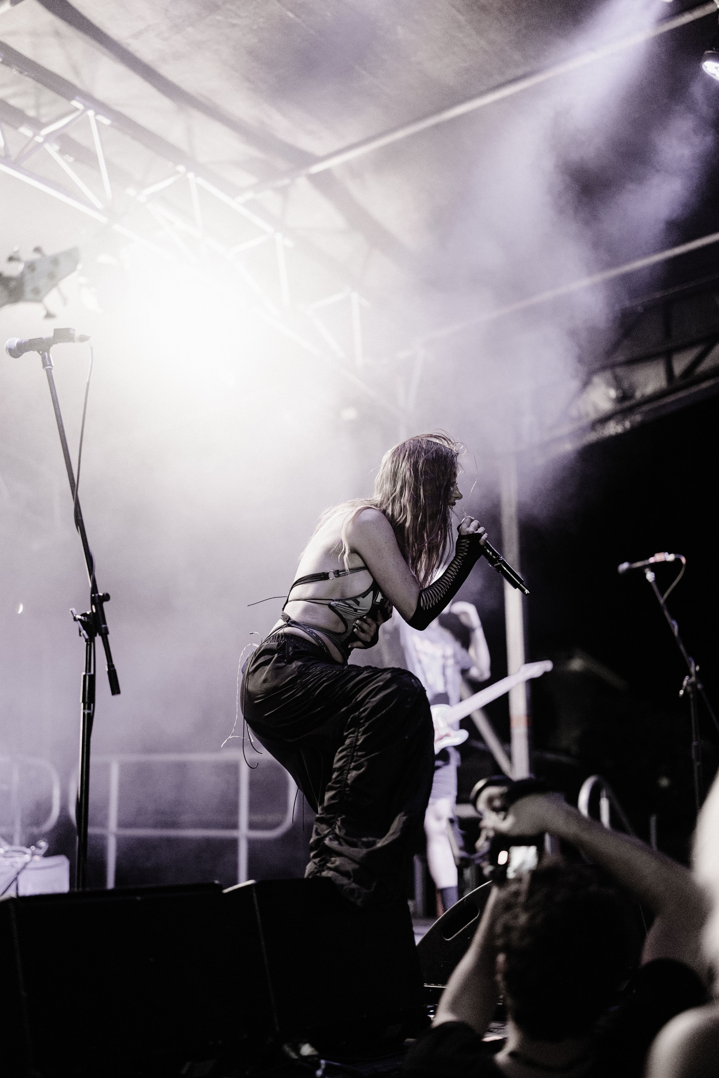 Dramatic backlit concert performance with fog machines and stage lighting creating atmospheric silhouette.