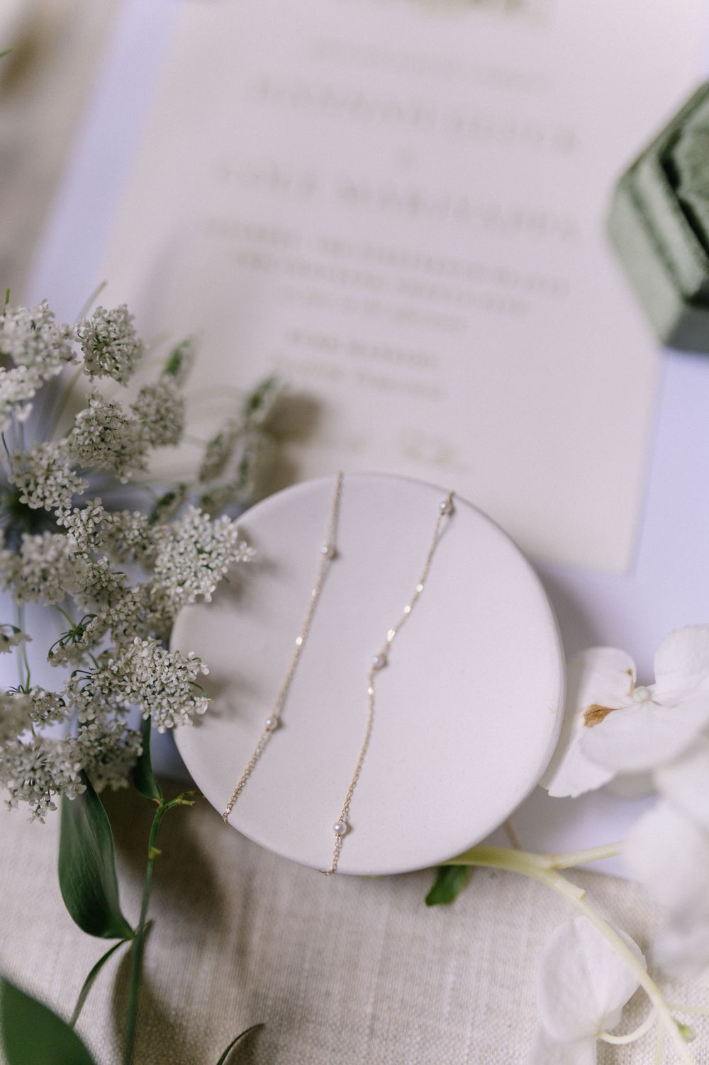 Delicate white floral arrangements with baby's breath and greenery displayed on linen tablecloths.