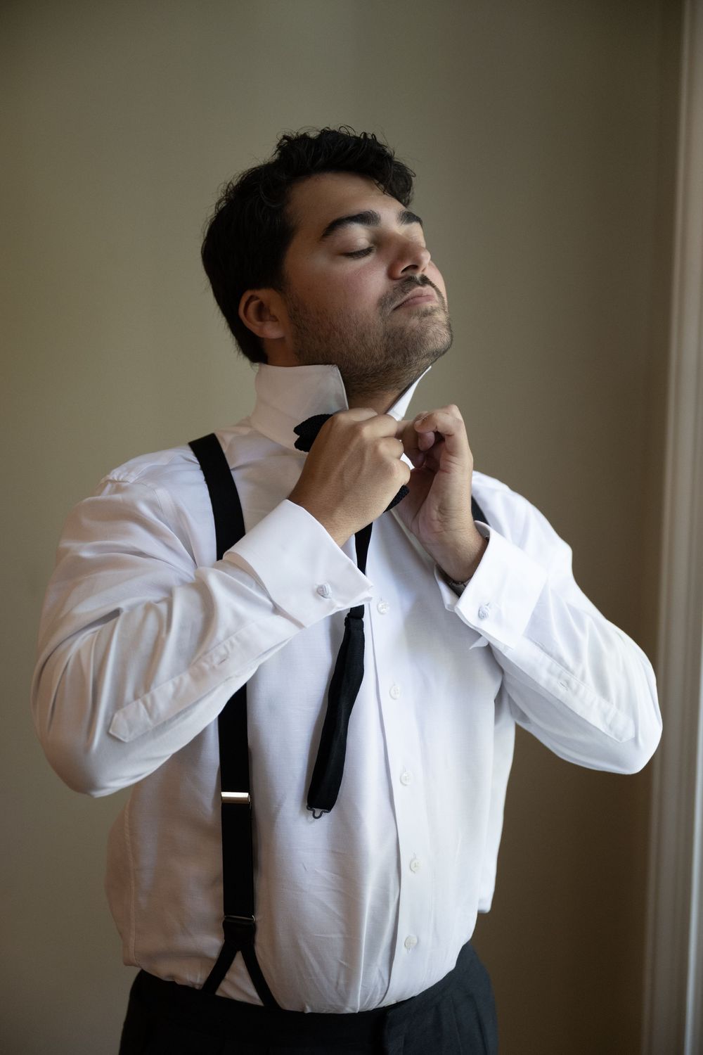 A sequence of dramatic black and white portraits showing someone in suspenders and white shirt tilting their head back.