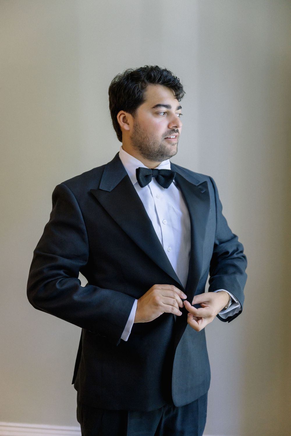 Series of shots showing a man adjusting his black tuxedo and bowtie before a formal event.