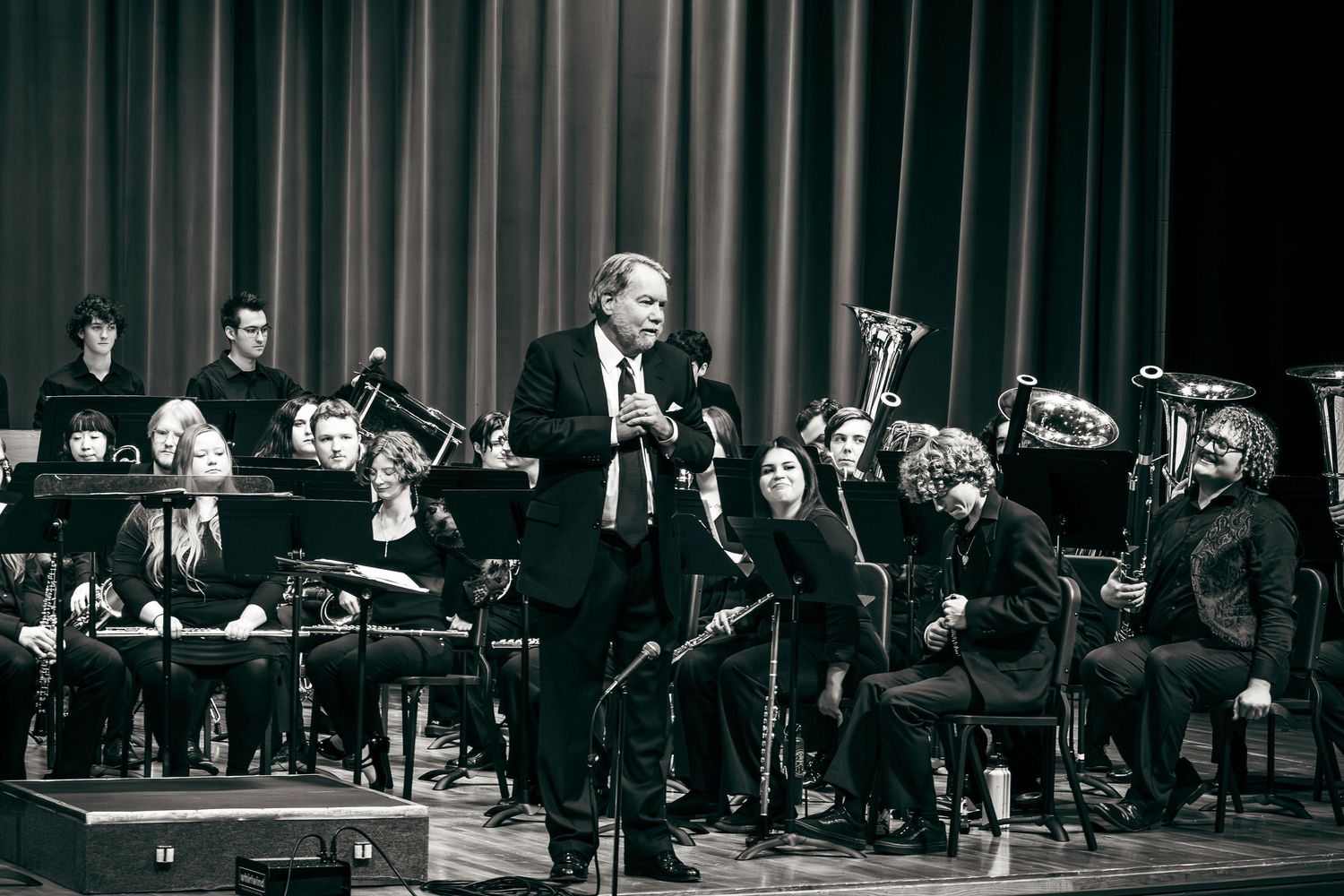 Musicians perform in an orchestra on stage during a classical concert performance.