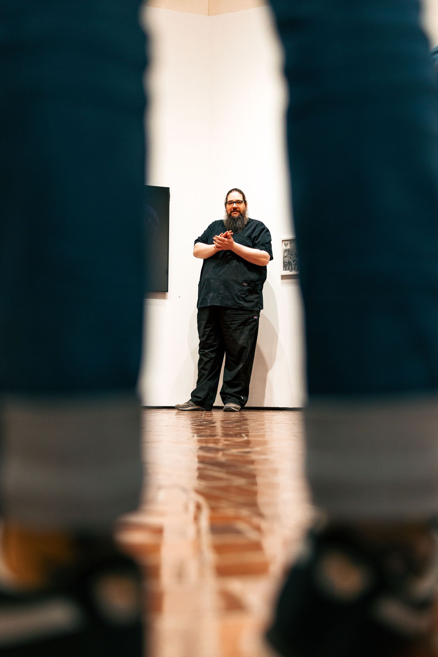 A sequence of photos showing a person in black leaning against a white wall in different poses.