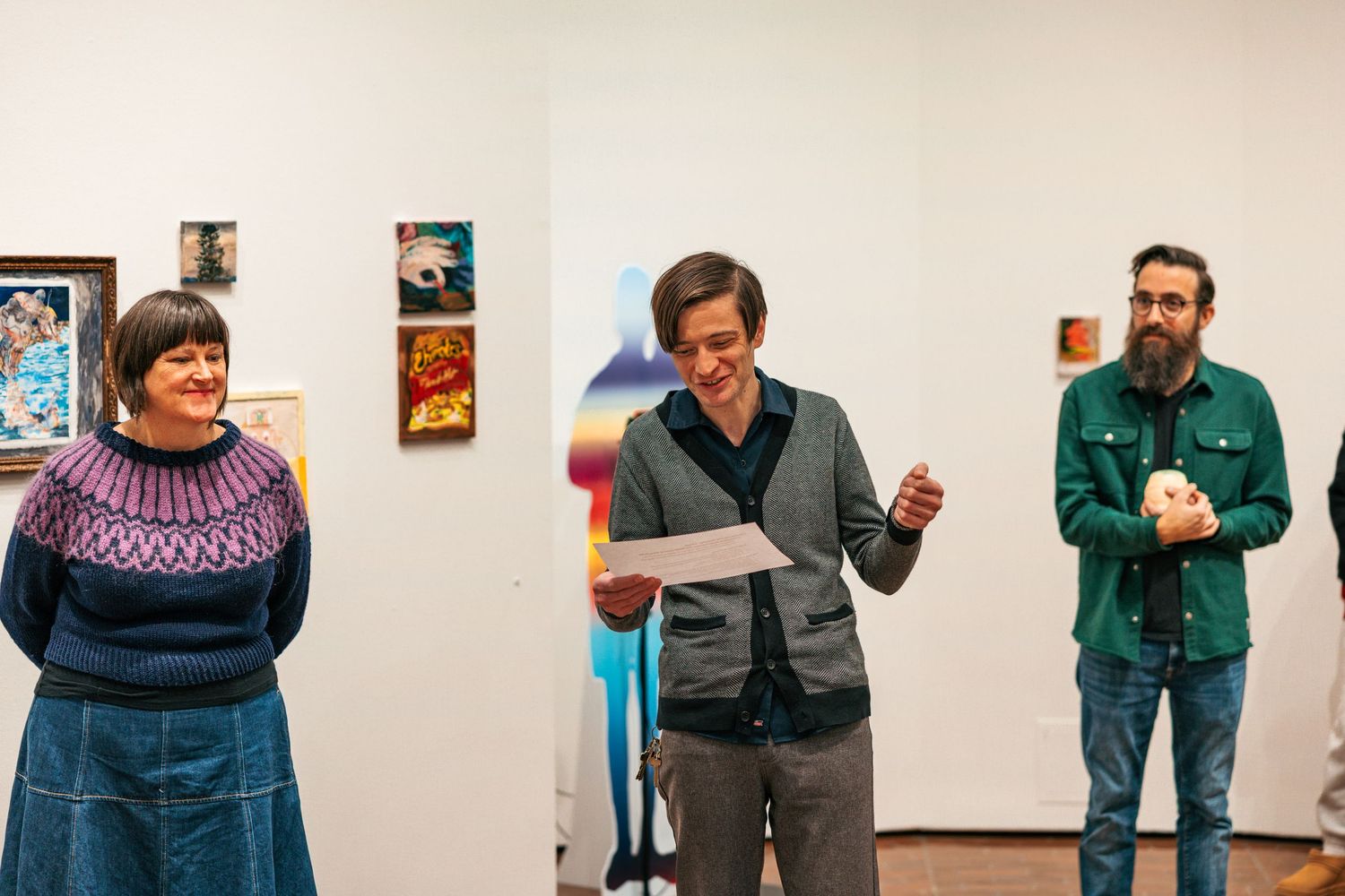 A series of connected photos showing people in casual attire interacting in an art gallery or exhibition space.