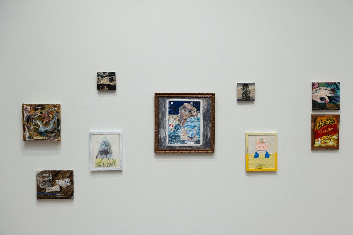 Art gallery wall displaying multiple framed pictures and artworks in a row against a white background.