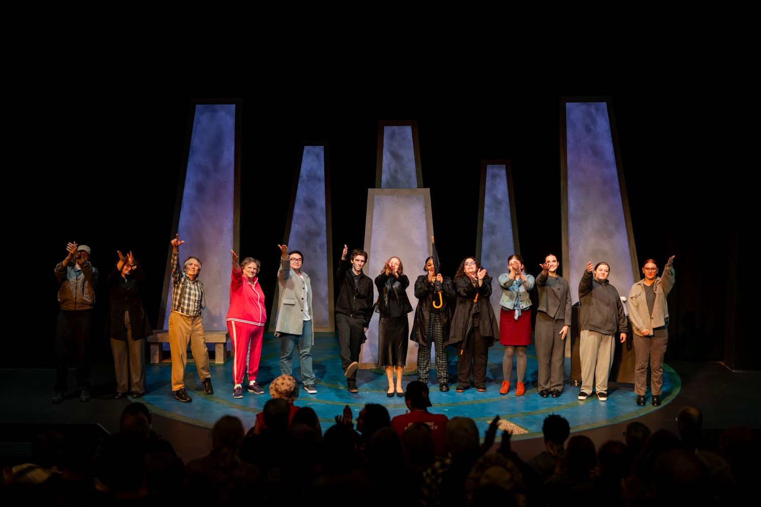 Theater performers take a bow on stage during curtain call at the end of a performance.