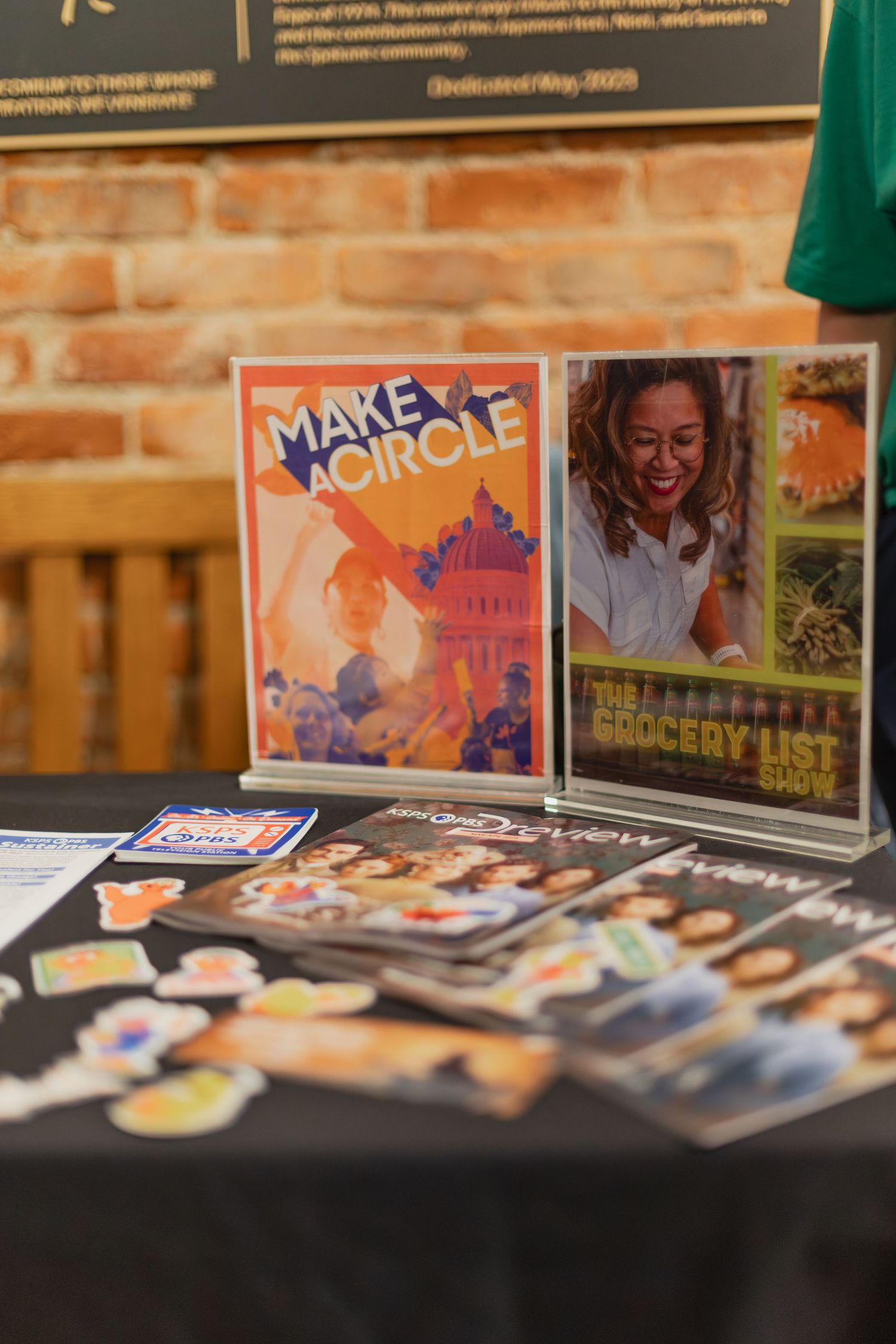 A display table at SpIFF film festival featuring Make a Circle and The Grocery List Show promotional materials with stickers.