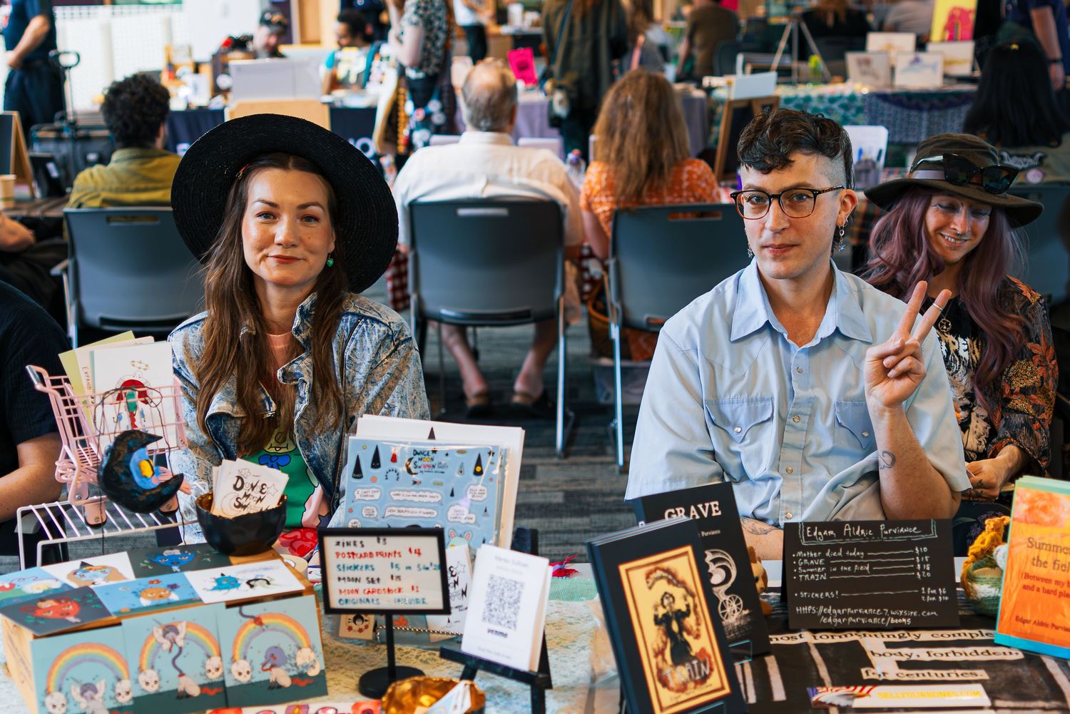 Artists and vendors display their creative work at a bustling indie craft fair marketplace.