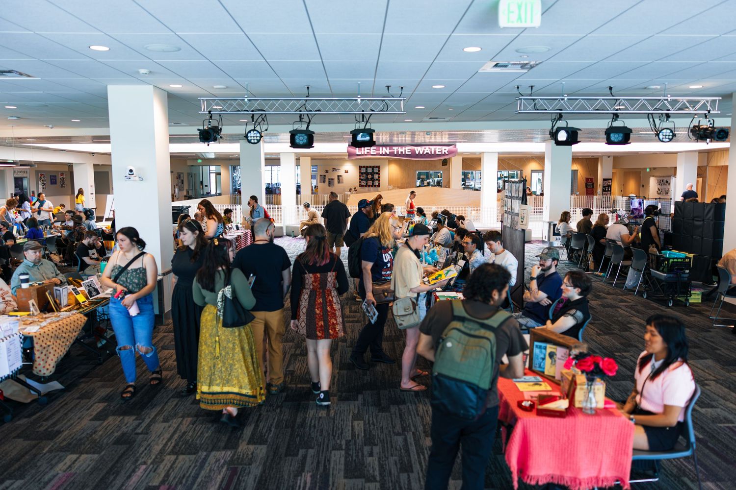 A large group of people gathered in an office space for a professional networking or social event.