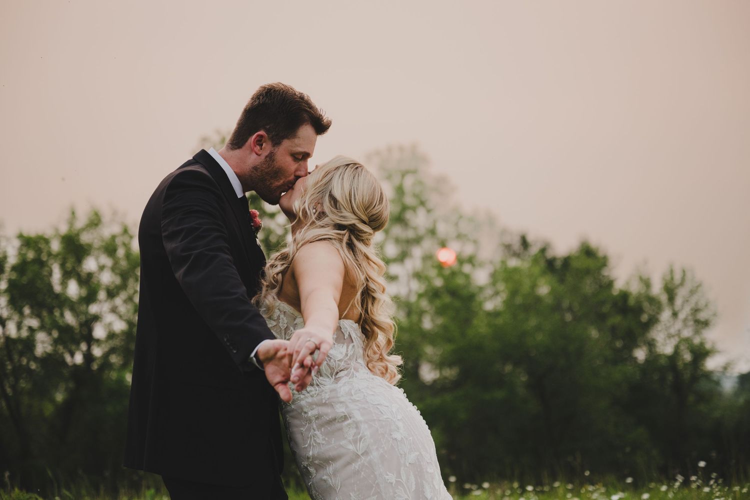 A romantic outdoor wedding photo collage showing tender moments between the couple in a natural setting at sunset.