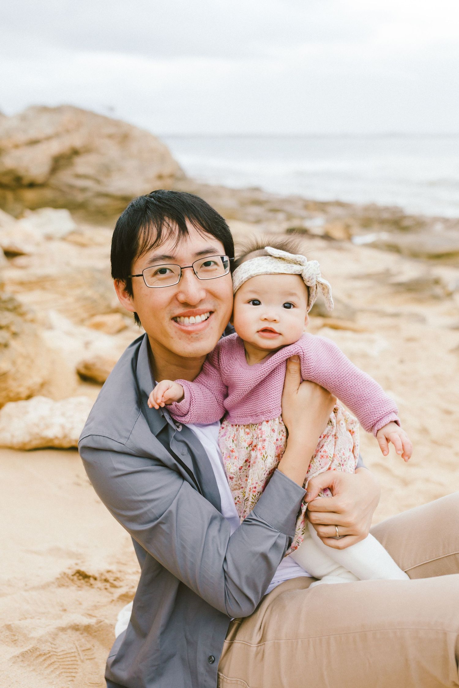 A heartwarming moment captured at a sandy beach with two people sharing joyful embraces and laughter.