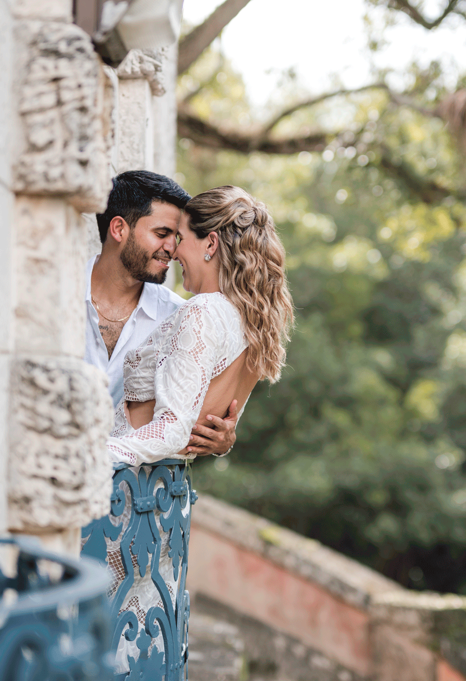 Couple embracing in garden during engagement session at Vizcaya Museum