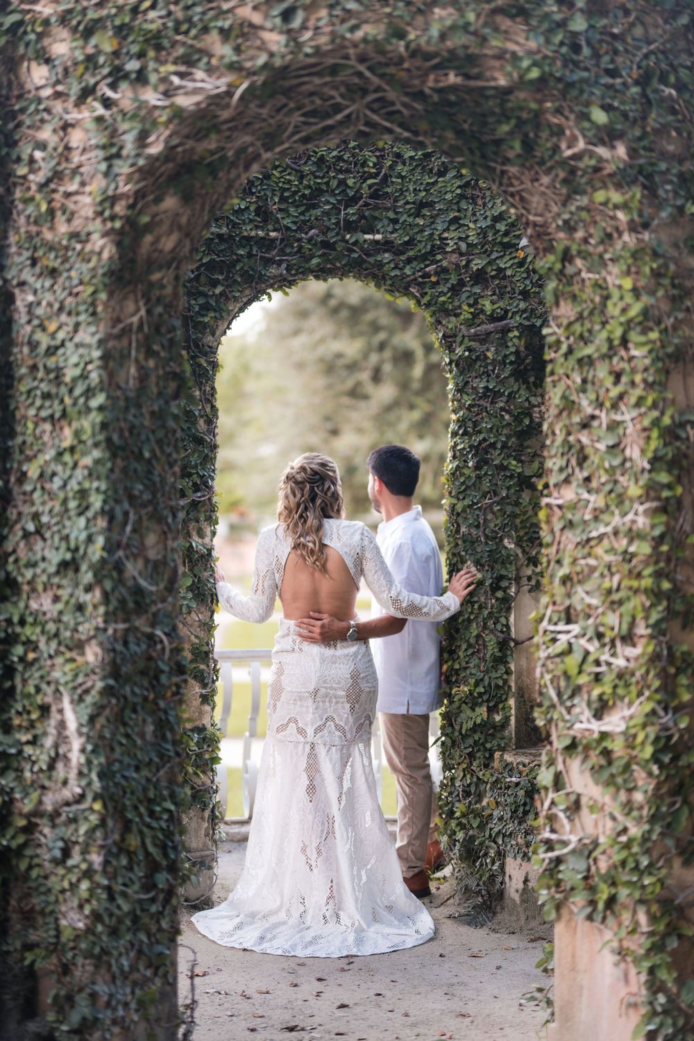 Couple standing under archway during engagement photos at Vizcaya Gardens