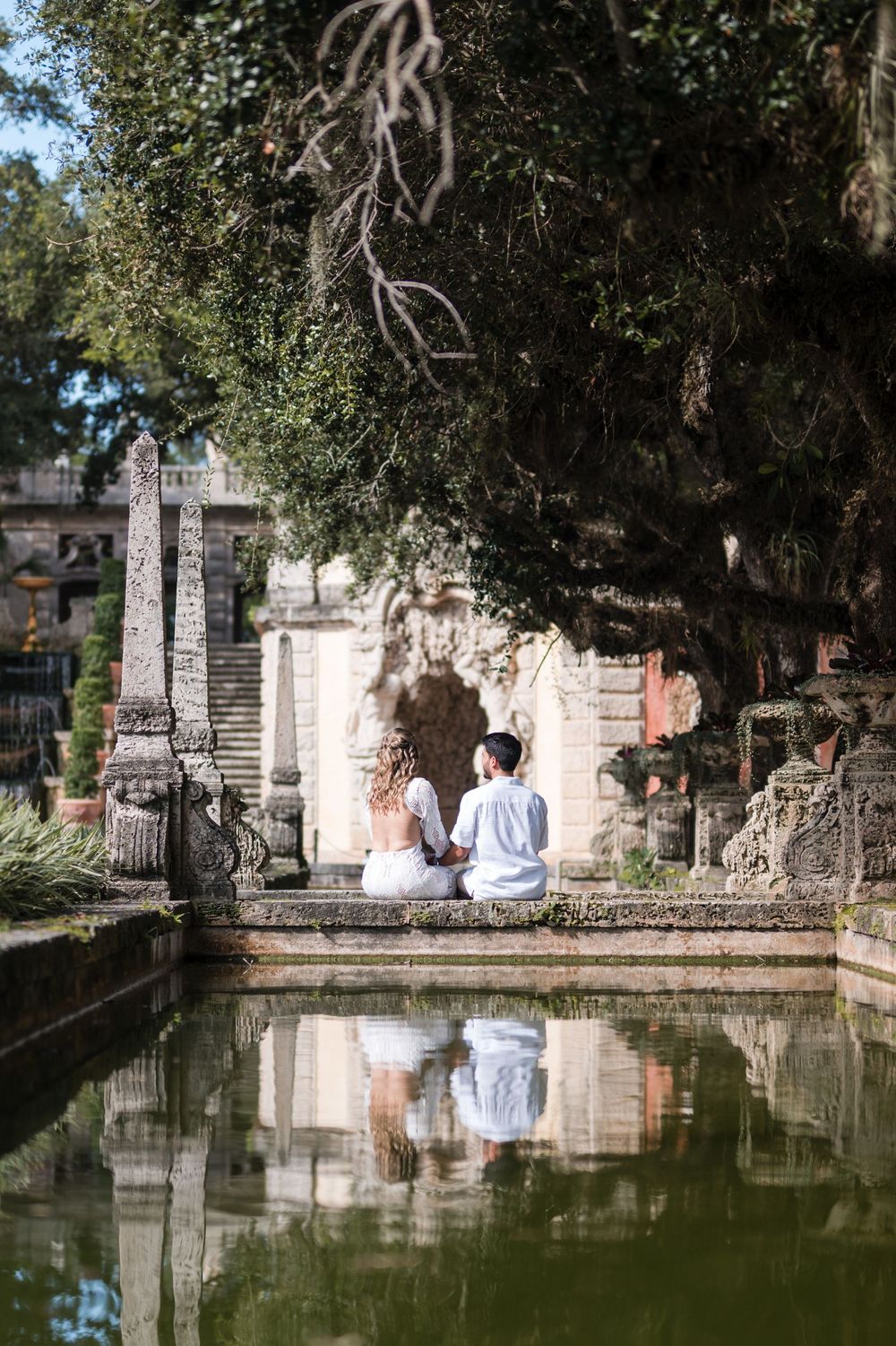 Couple reflected in water during engagement session at Vizcaya Miami