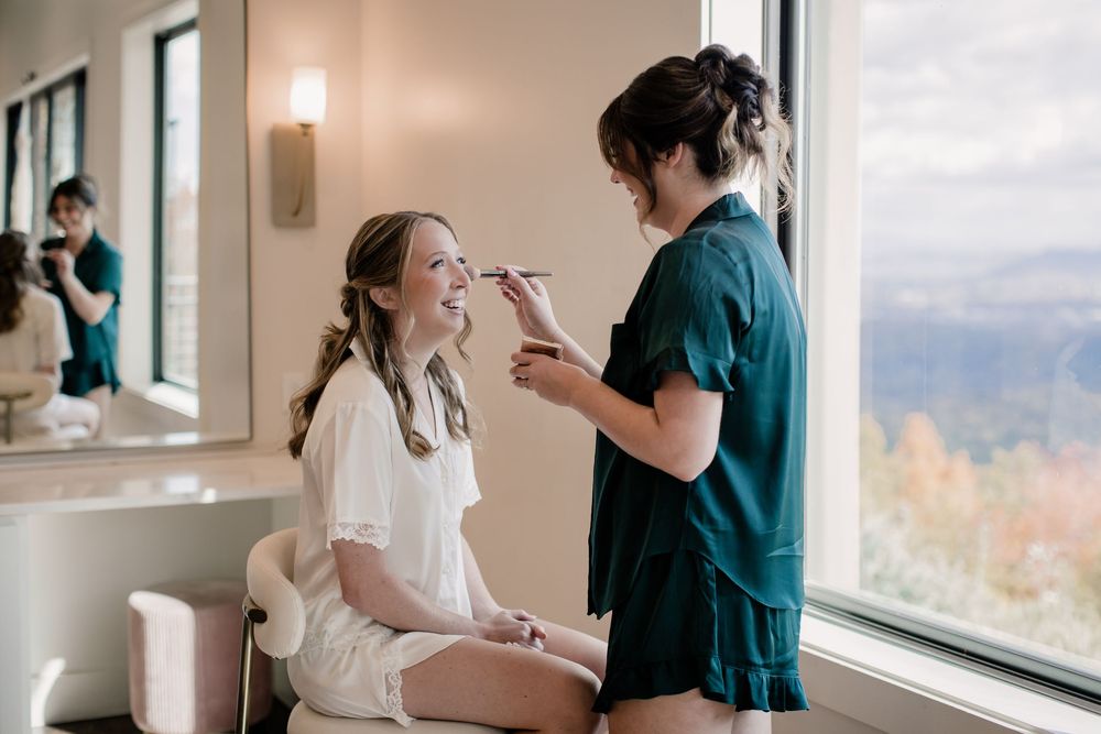 Wedding preparation scene by a window with natural light streaming in.