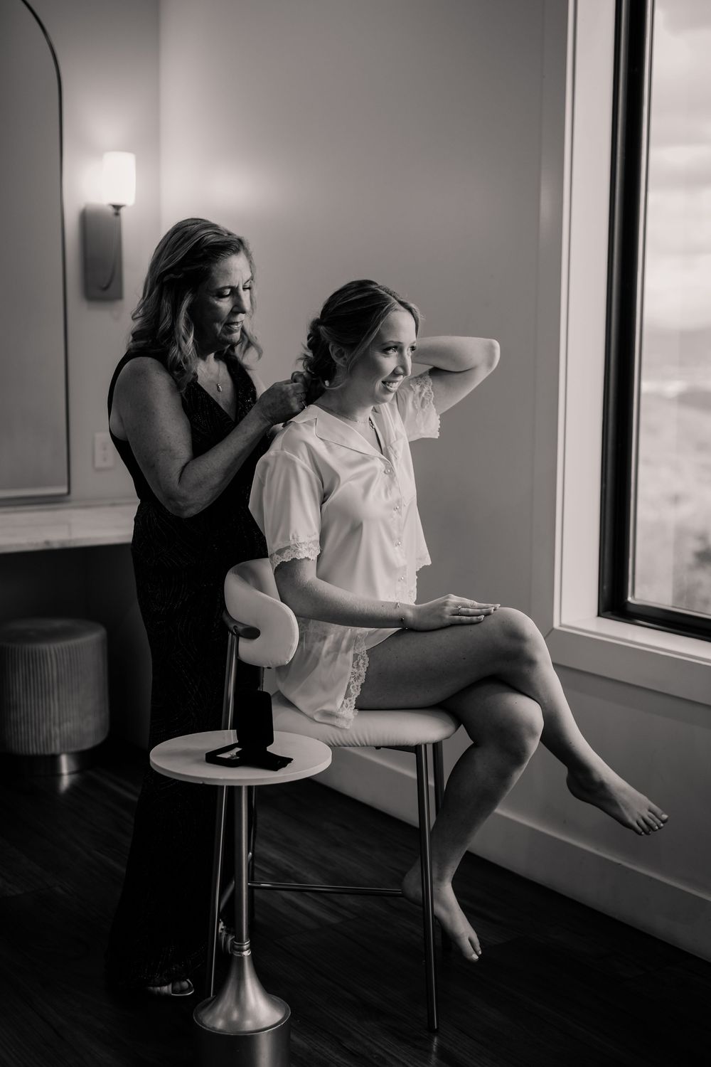 Black and white getting ready photos in modern room with window light.